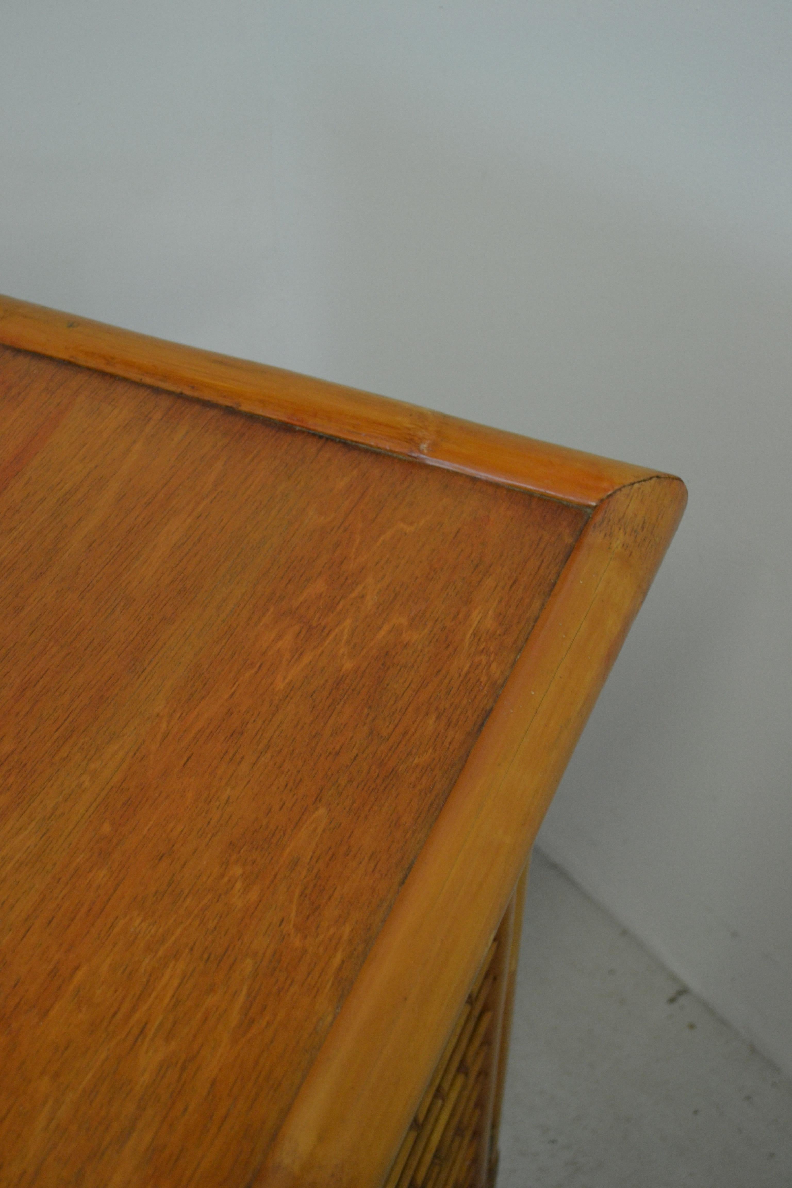 
Elegantes französisches Sideboard aus den 1950er Jahren, gefertigt aus Bambus, Glas und Messing, im unverwechselbaren rustikal-modernen Stil von Audoux-Minnet. Die Struktur besteht aus drei Türen und Seitenpaneelen mit Bambus-Gitterwerk über