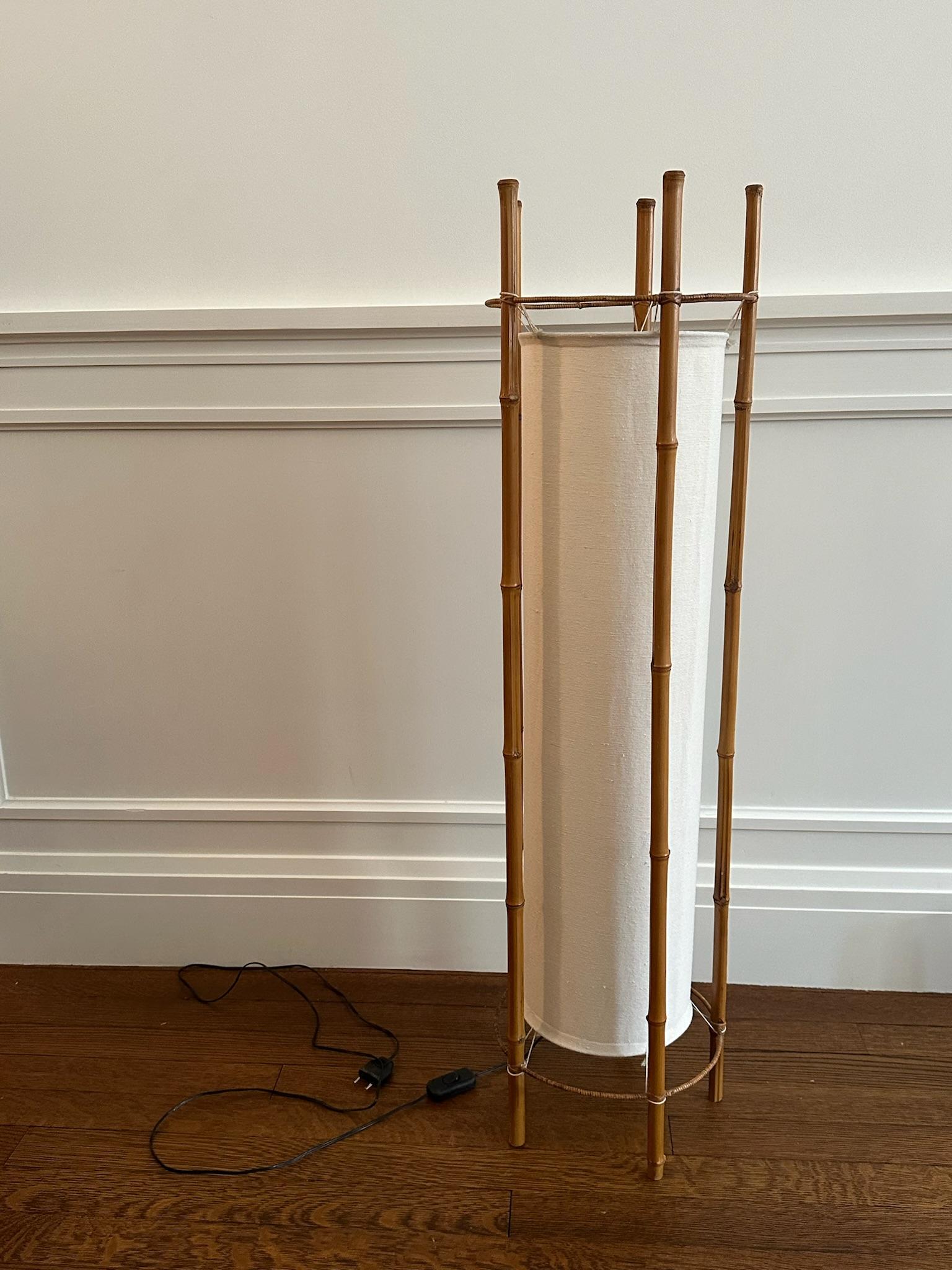 Unique bamboo floor lamp with cream canvas shade by Louis Sognot. Needs to be rewired to meet US standards. 