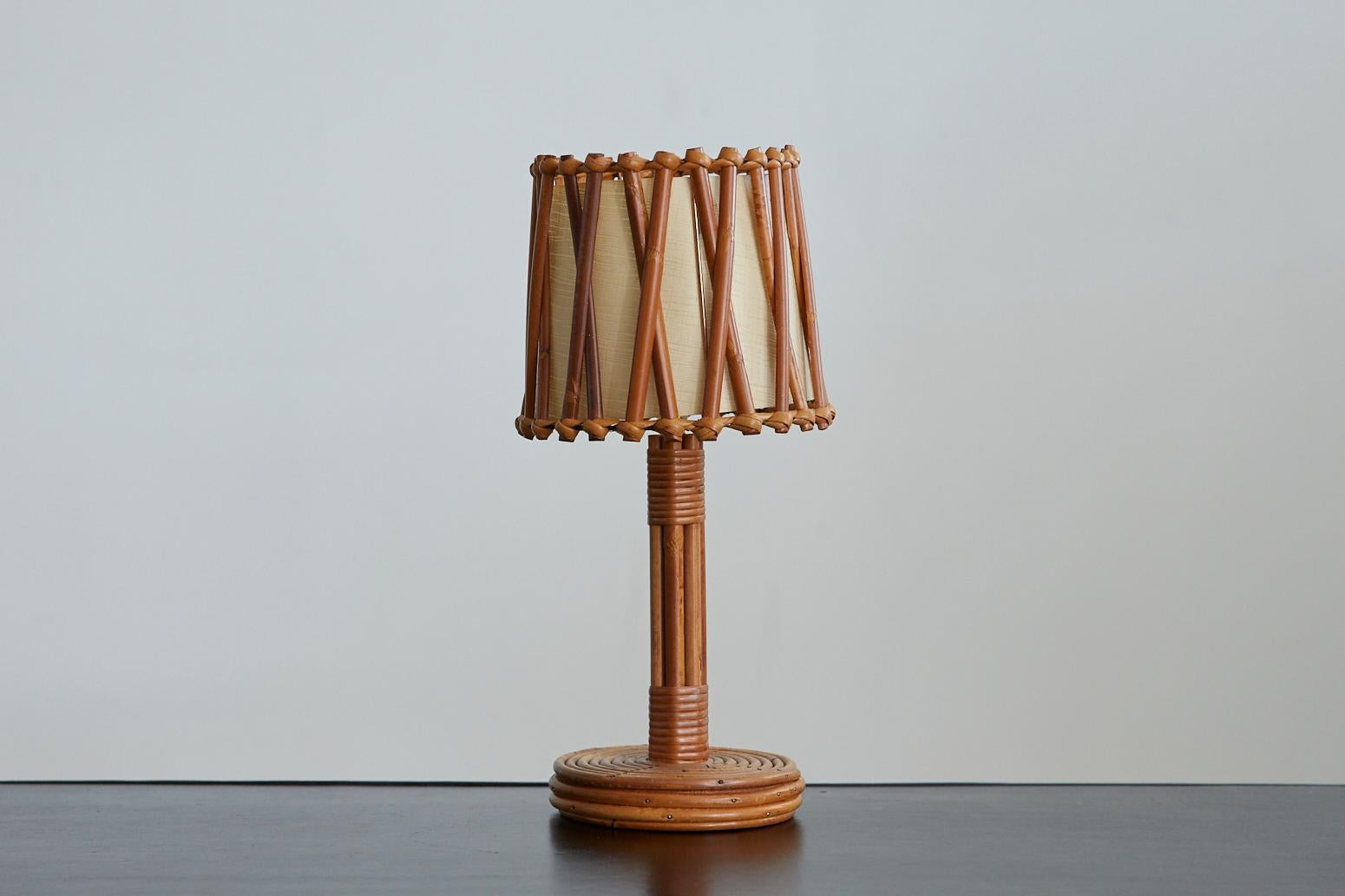 Petite French bamboo table lamp with original bamboo shade and paper diffuser. Circular bamboo base and stem with wrapped rattan detail. Newly re-wired.