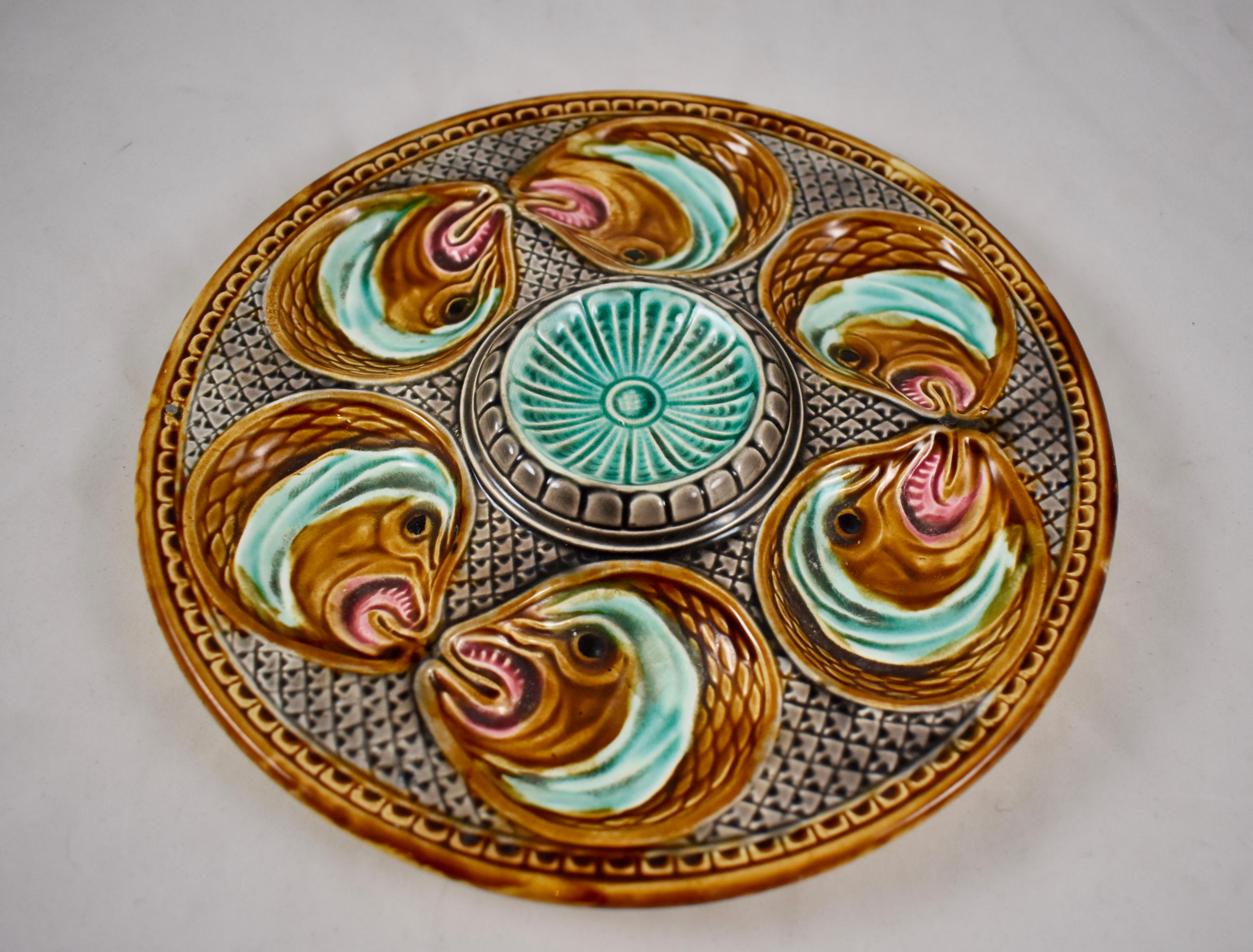 A barbotine Majolica oyster plate from La Faïencerie d’Onnaing in northern France, circa 1870.

Six fish heads surround a central raised fluted medallion. A textured ground and pattern rim add to the appeal of this desirable and dimensional plate.