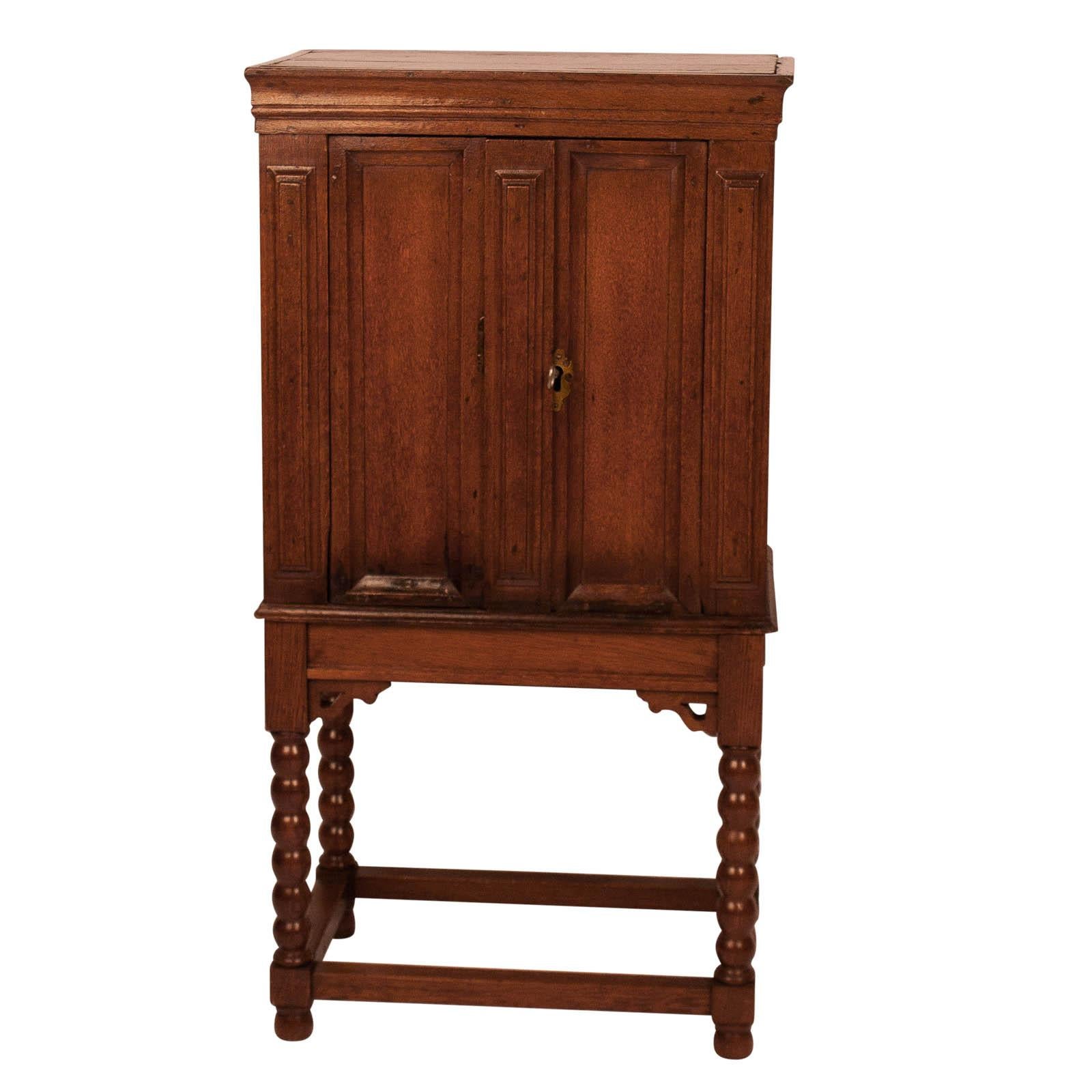 An early 19th century French Baroque ash or elm cabinet on later matching stand, France, circa 1800.

