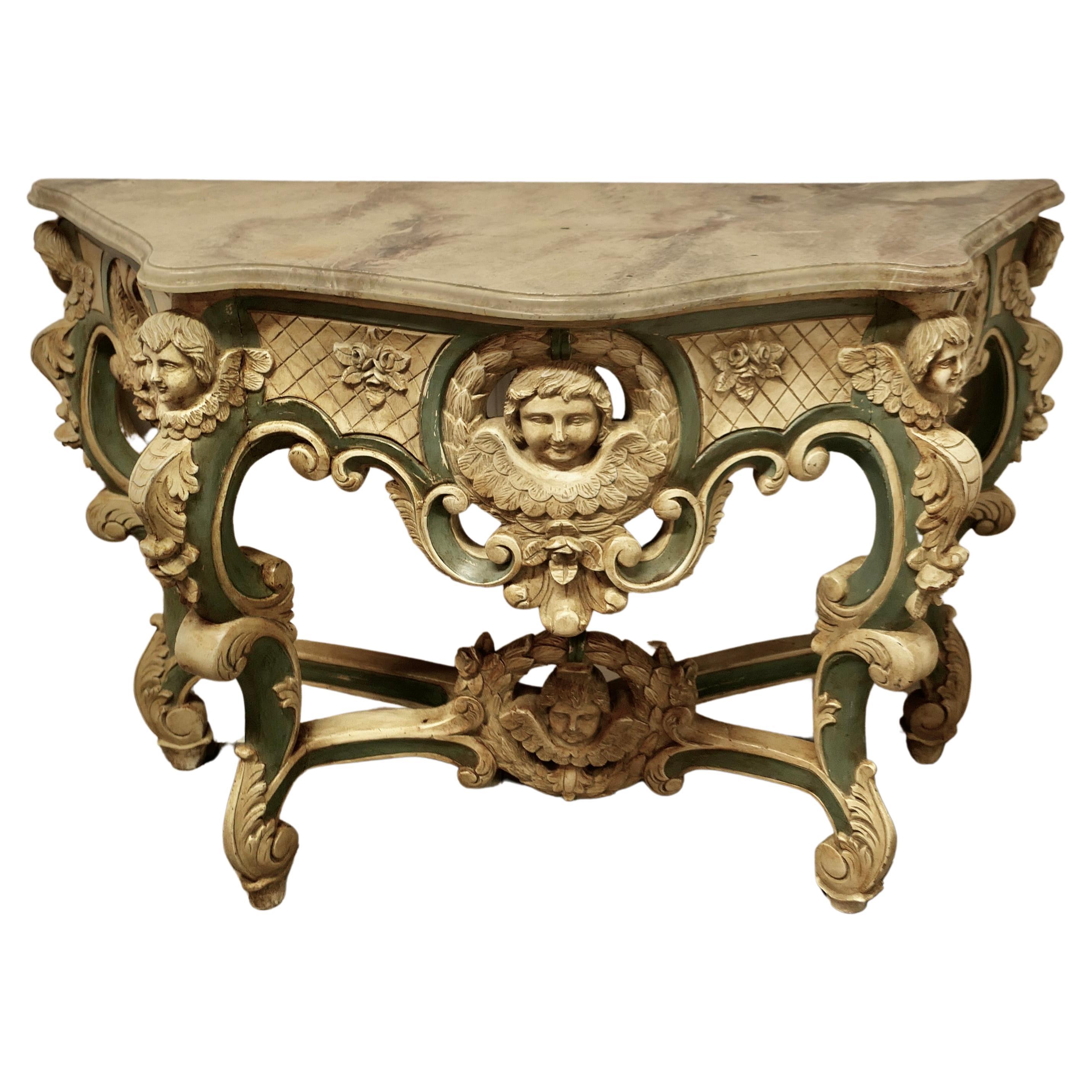  Table console baroque française, sculptée et peinte représentant les visages d'anges