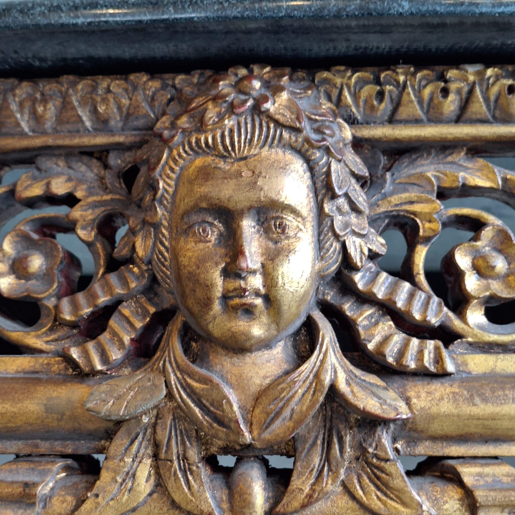 Late 18th-century French Baroque console table. Made of molded, carved, and gilded wood, with a central face surrounded by knotted ribbons, garlands, and openwork oak leaves.

It rests on six tapered, fluted and rudentate legs, topped with asparagus