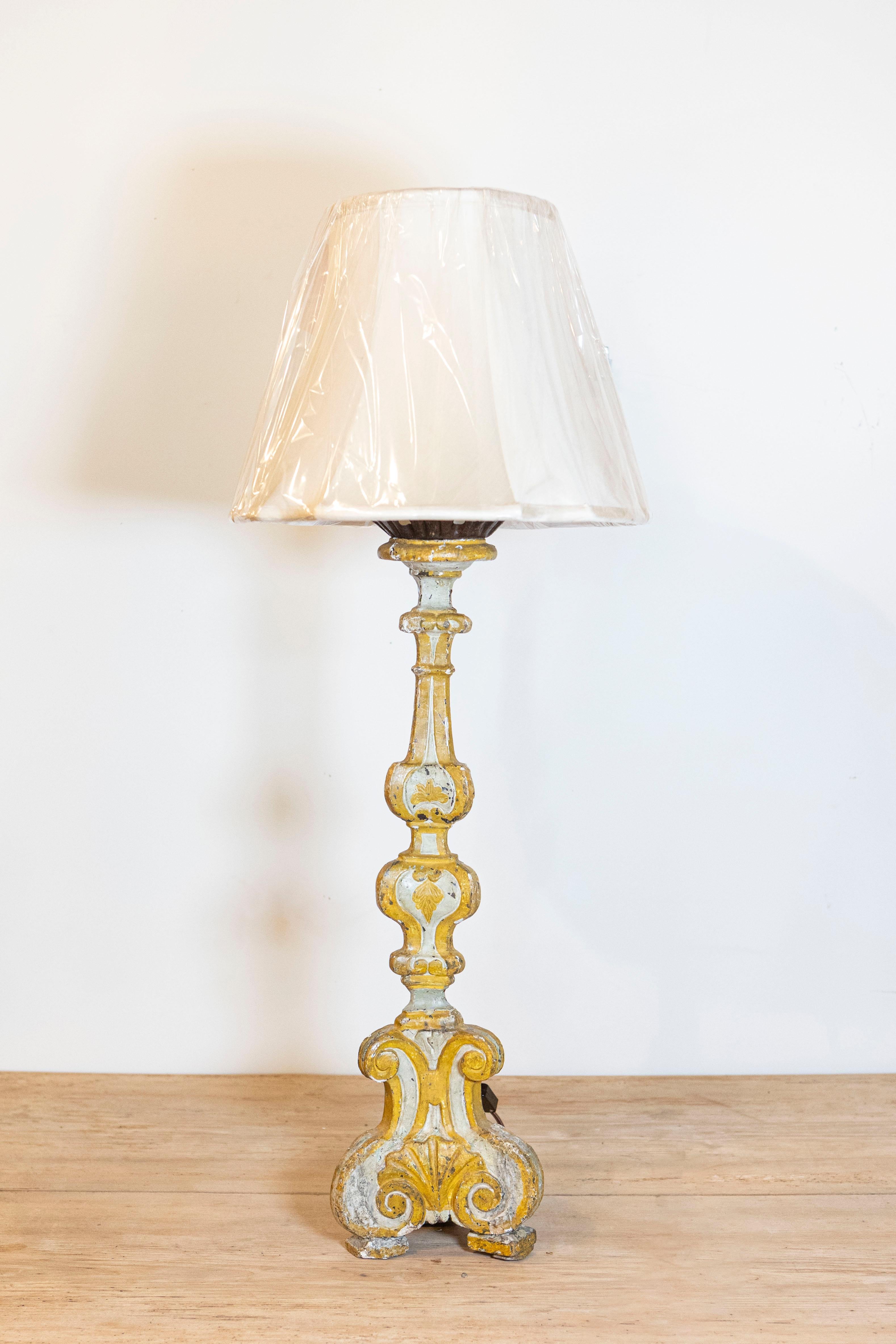 Candelero de madera tallada, pintada y dorada en paquete, de estilo barroco francés, del tercer cuarto del siglo XIX, convertido en lámpara de sobremesa, pantalla incluida. Nacido en los últimos años del último emperador de Francia, Napoleón III,