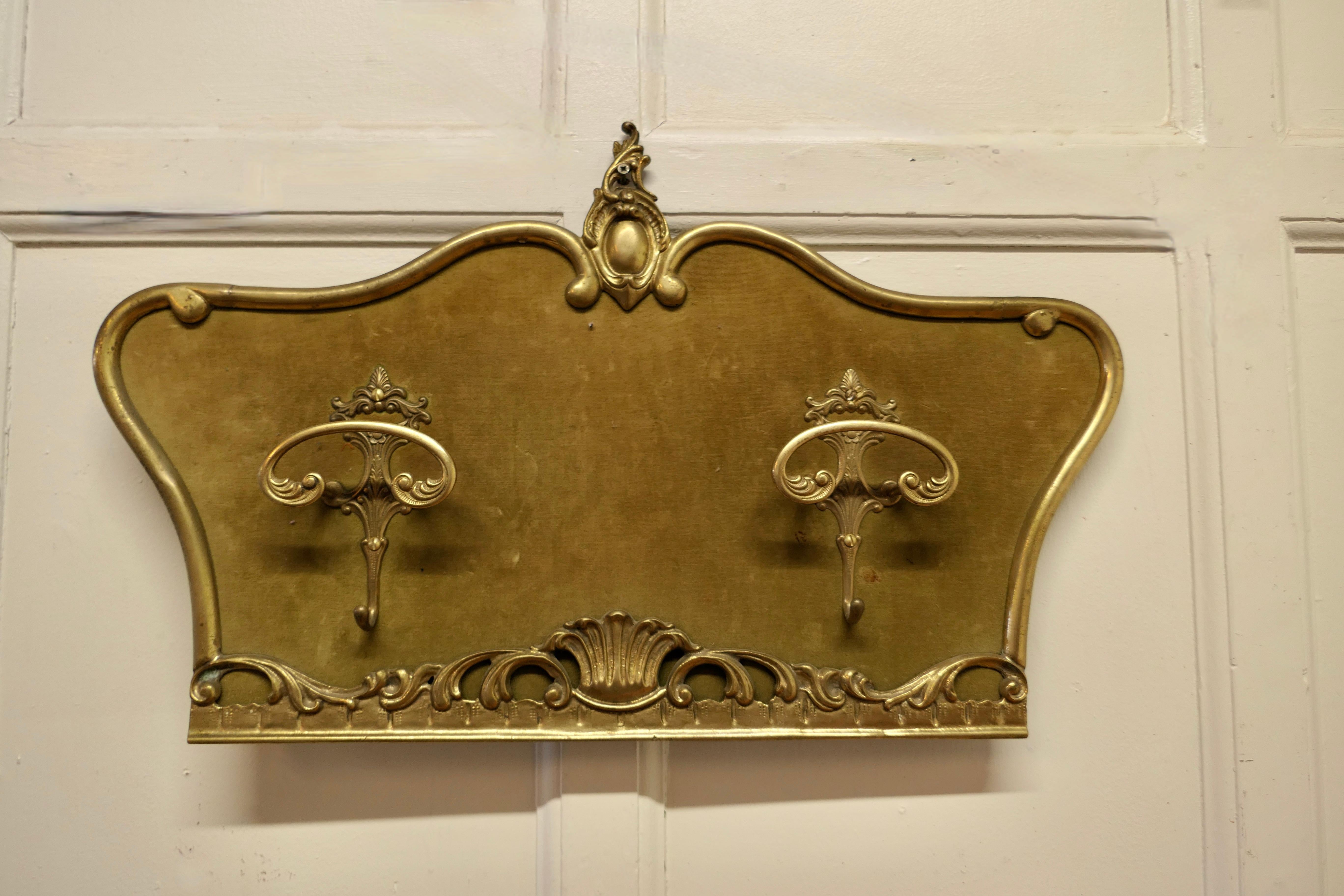 French Baroque style brass and velvet coat hanger

A very grand piece decorated in the Baroque Style with 2 large cloak hooks each has a smaller hook below
The Hooks are set on a velvet covered panel surmounted with a decorative Regal brass