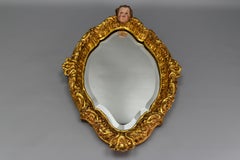 French Baroque Style Gilt Wood Wall Mirror with a Cherub Head