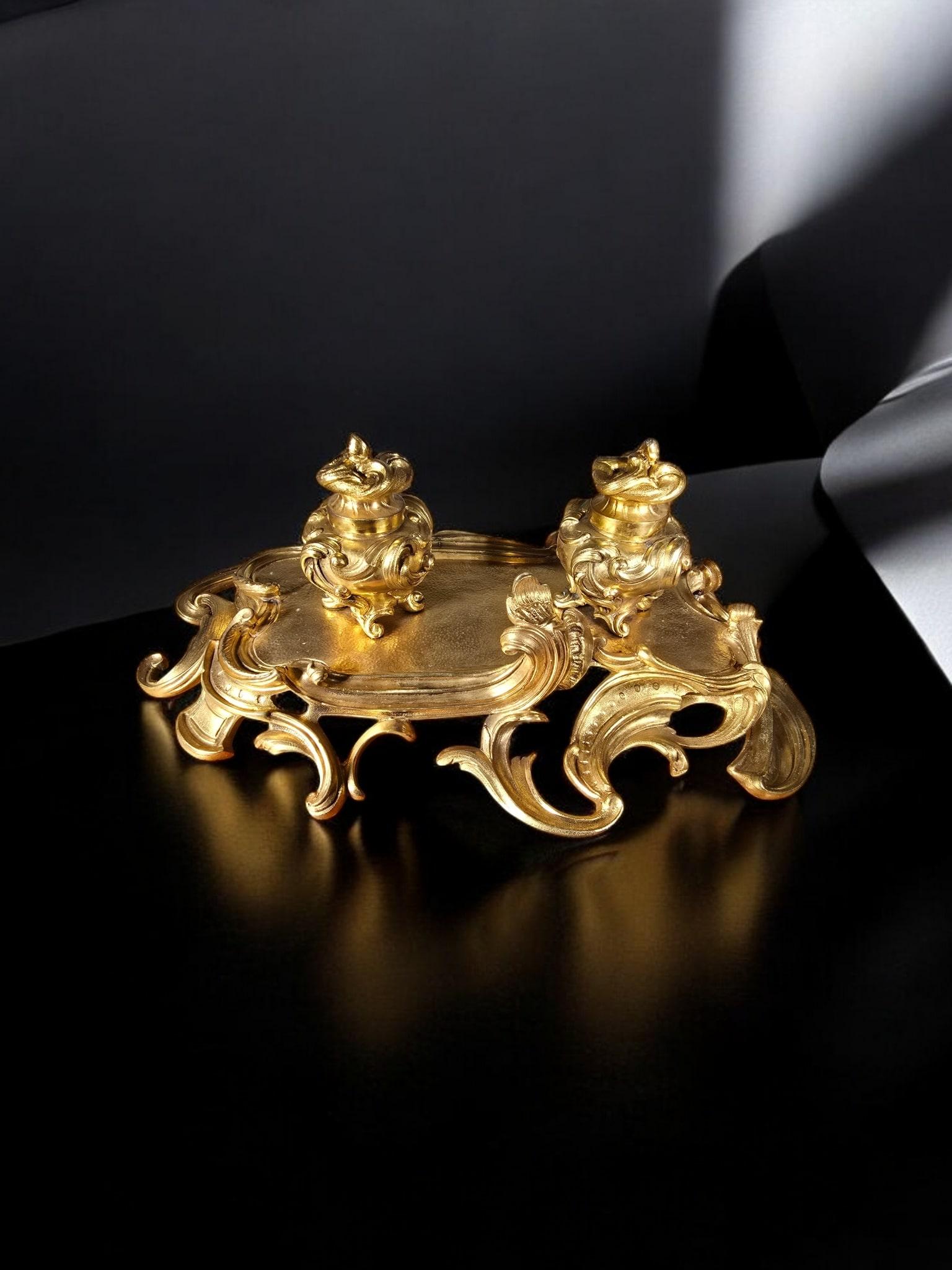 Un elegante calamaio francese realizzato in bronzo dorato in stile barocco del XIX secolo. Questo lussuoso pezzo riflette l'arte intricata e l'opulenza tipica dell'arredamento di ispirazione barocca.

Caratteristiche:

Materiale: Bronzo massiccio