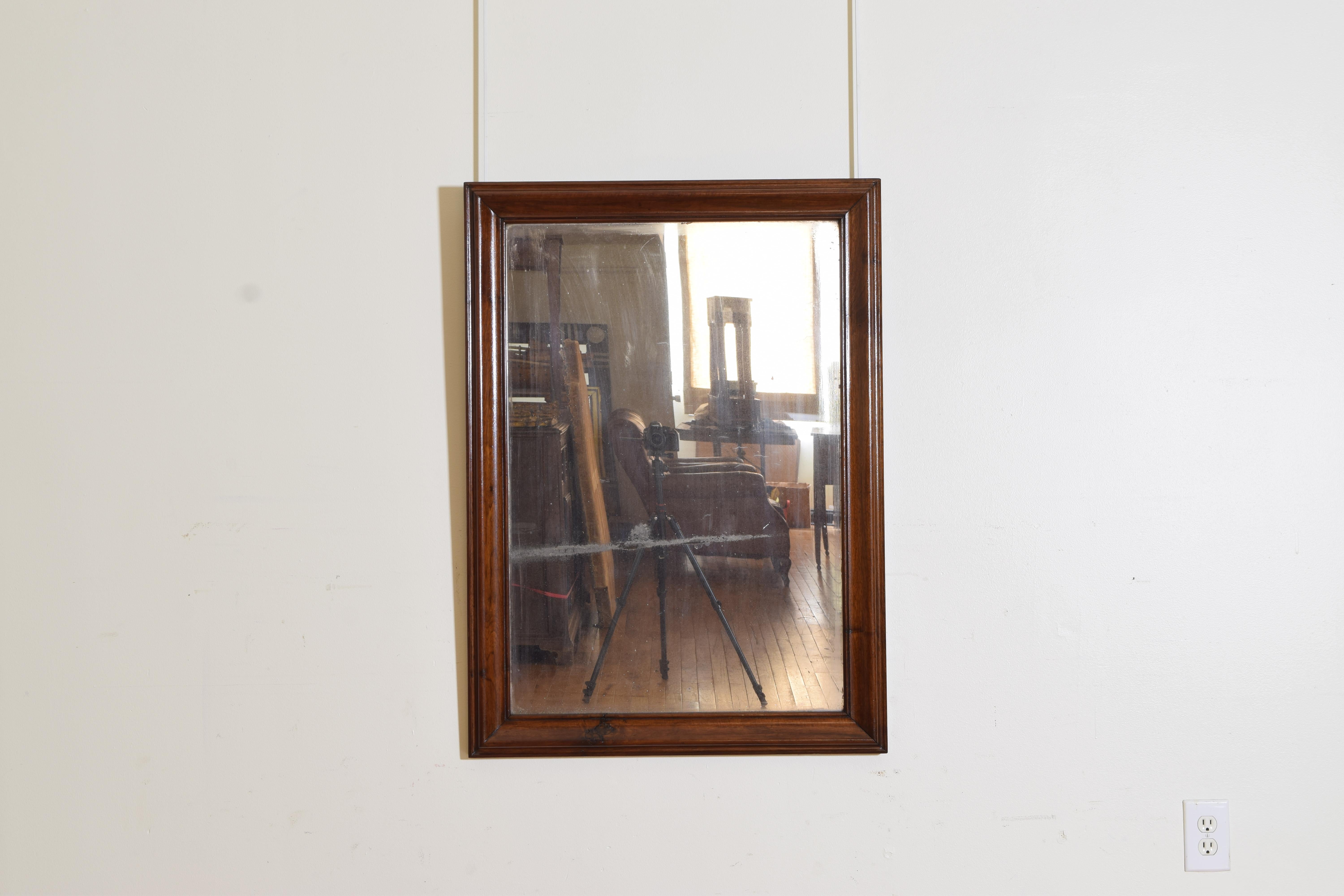 Constructed entirely of solId walnut this mirror has several different moldings within the frame and retains its original glass.