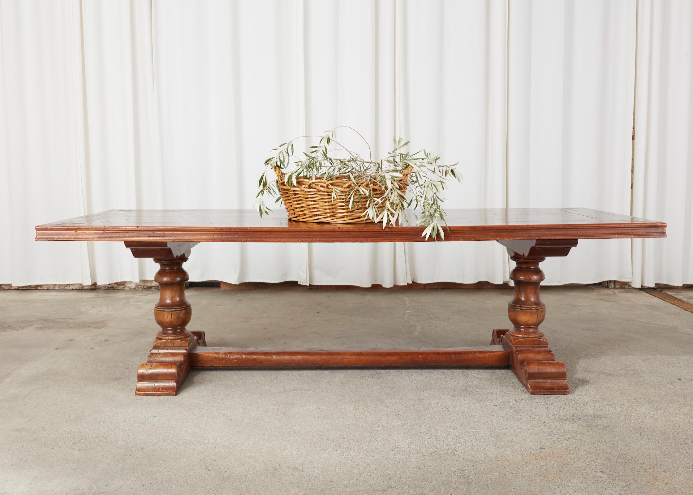 Magnificent French walnut trestle dining table or refectory table hand-crafted in the baroque monastery style. The table features an inlaid top made of thick hand-formed timbers decorated with a black accent and a French fleur de lis design on each