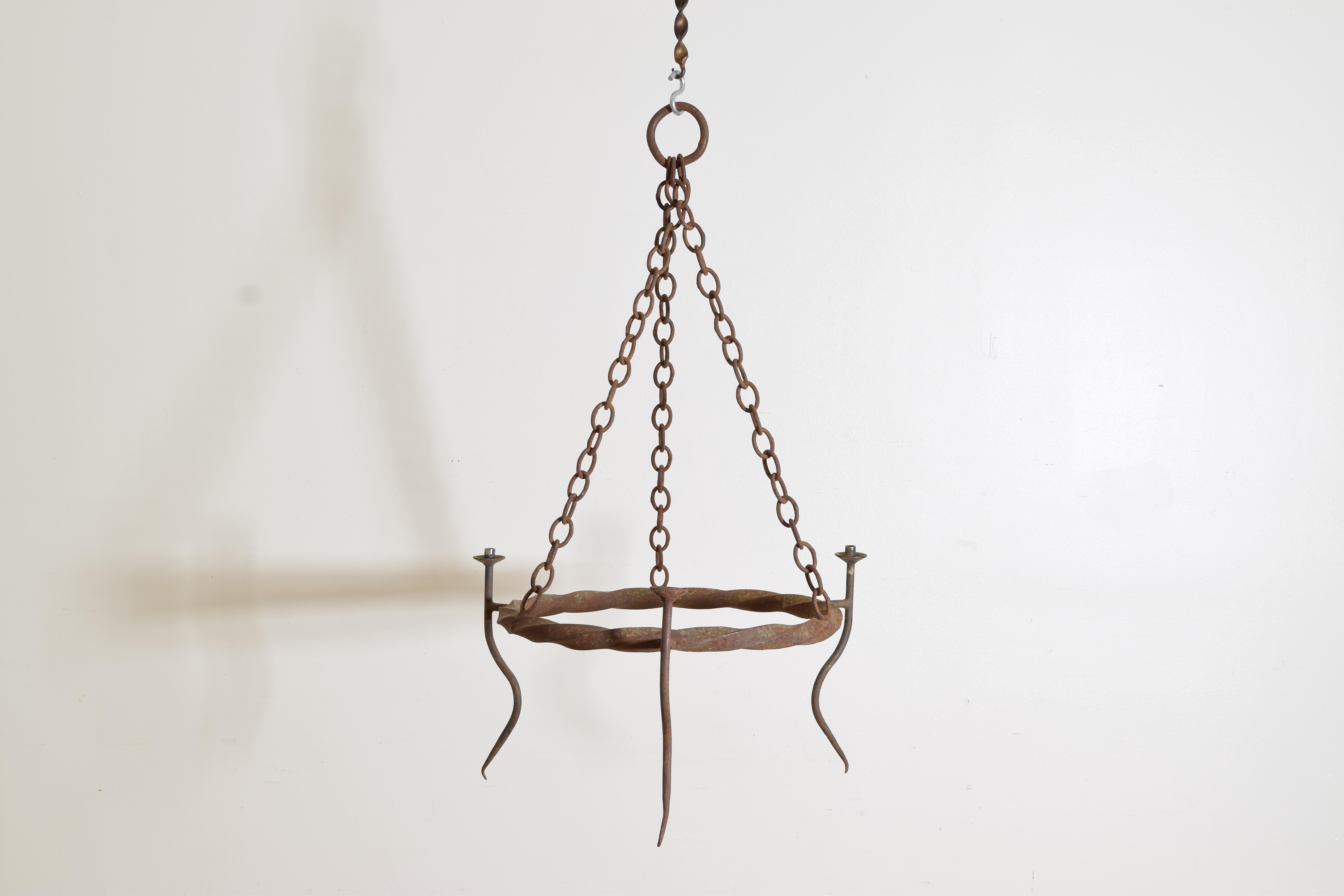With three strands of original chain hanging from a large wring, the circular frame of twisted iron issuing three serpentine form arms