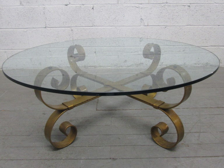 French Baroque style wrought iron coffee table with round glass top.