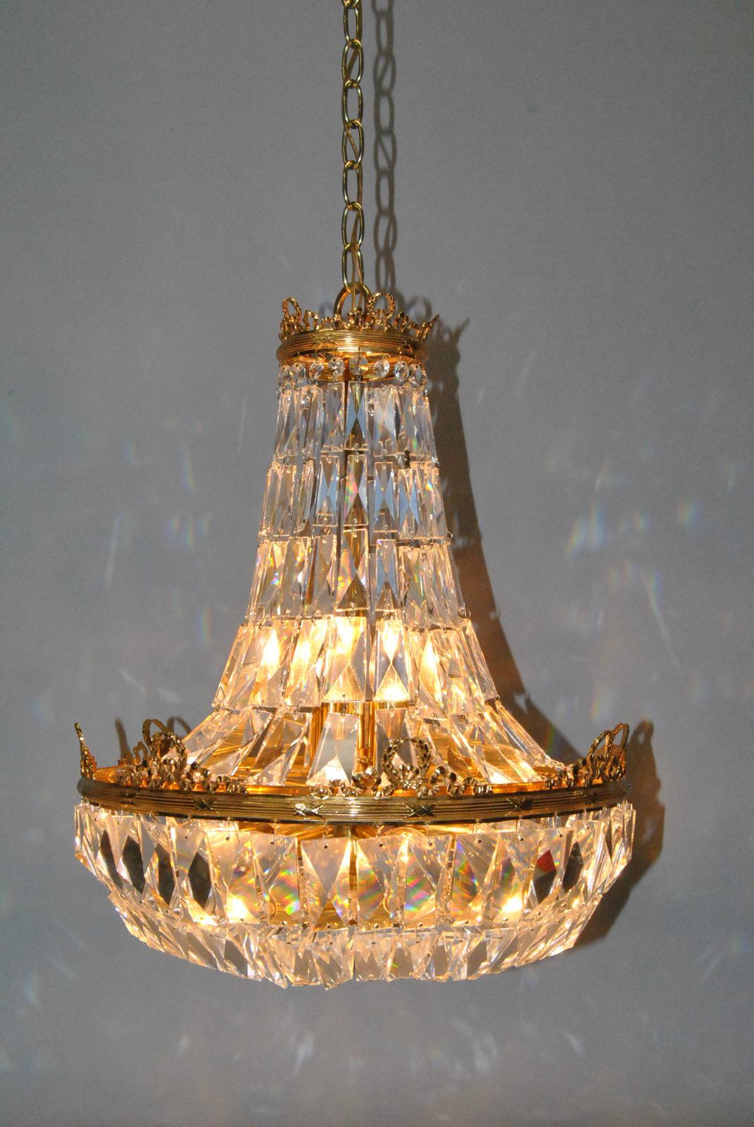 Beautiful elegant French basket form crystal chandelier. This chandelier was made in the 1970s and has rectangular cut crystals in a basket form. Crystals drape around an ornate brass frame with wreath and ribbon accents. Nine sockets provide great