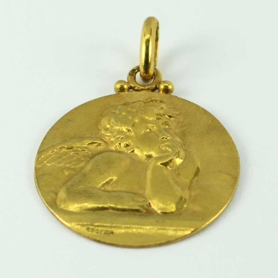 A French 18 karat (18K) yellow gold charm pendant medal designed by Edmond Henri Becker depicting Raphael's contemplative cherub against clouds to one side with a rose surrounded by ivy on the reverse. Engraved Becker, stamped with the eagle's head