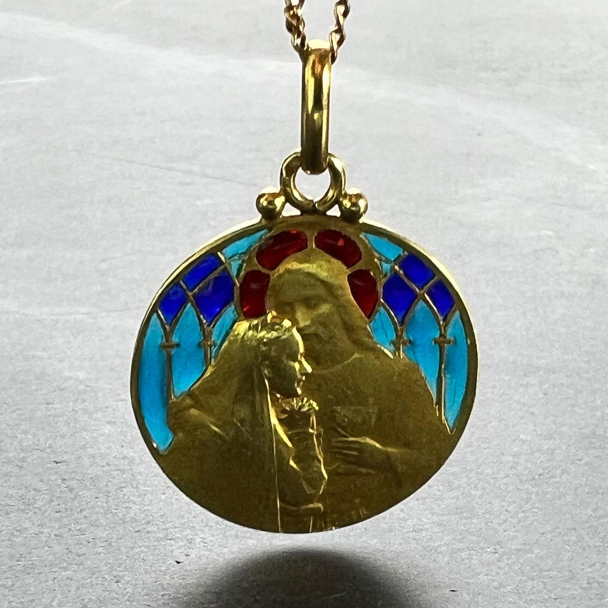 A French 18 karat (18K) yellow gold pendant designed as a round medal depicting the moment of Holy Communion, with Jesus Christ holding the goblet in one hand, and resting His other hand on the shoulder of the veiled recipient. Set with red, blue