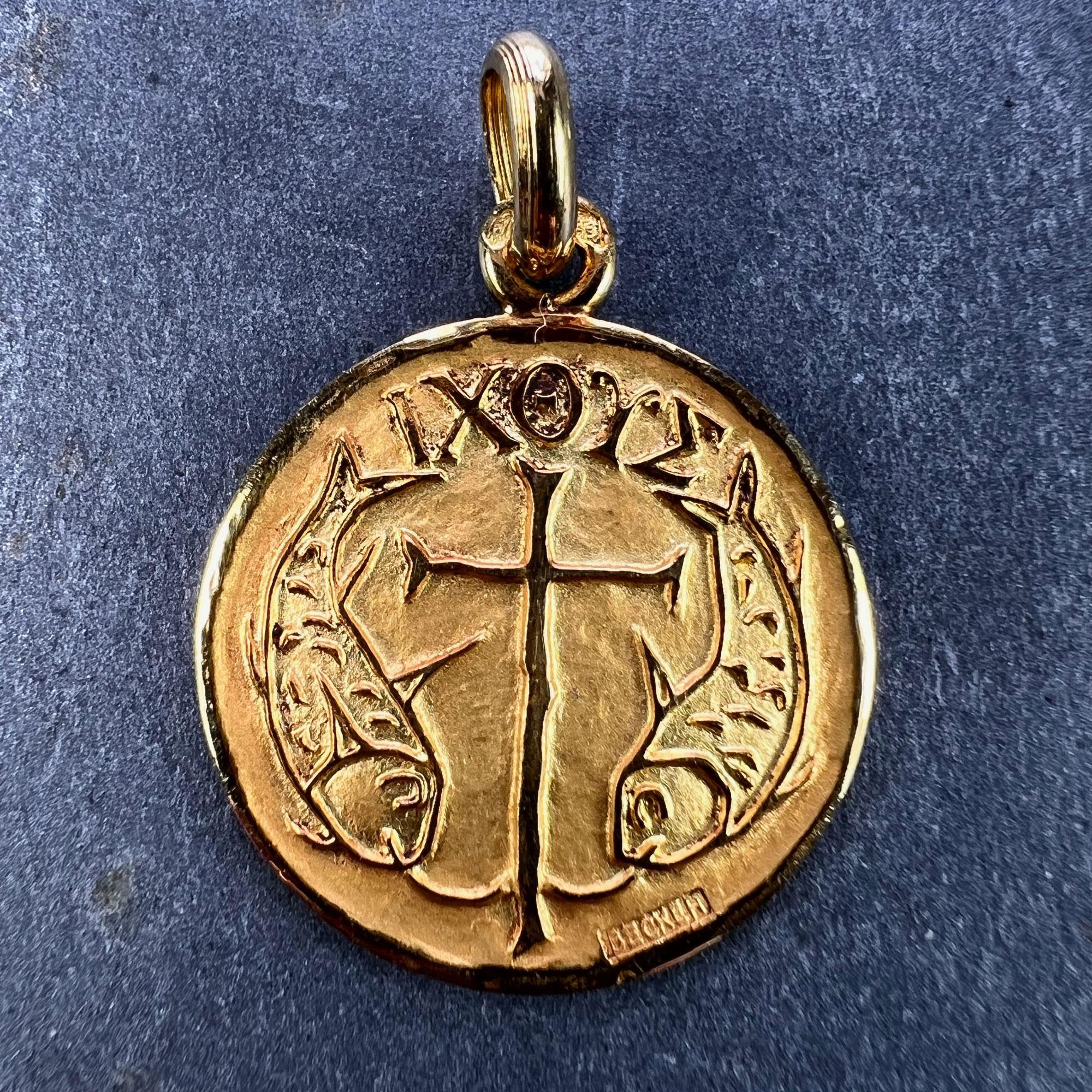 A French 18 karat (18K) yellow gold religious charm pendant depicting a pair of fish surrounding a cross, with the word IXOYE above. Signed Becker and stamped with the eagle's head for French manufacture and 18 karat gold with an unknown maker’s