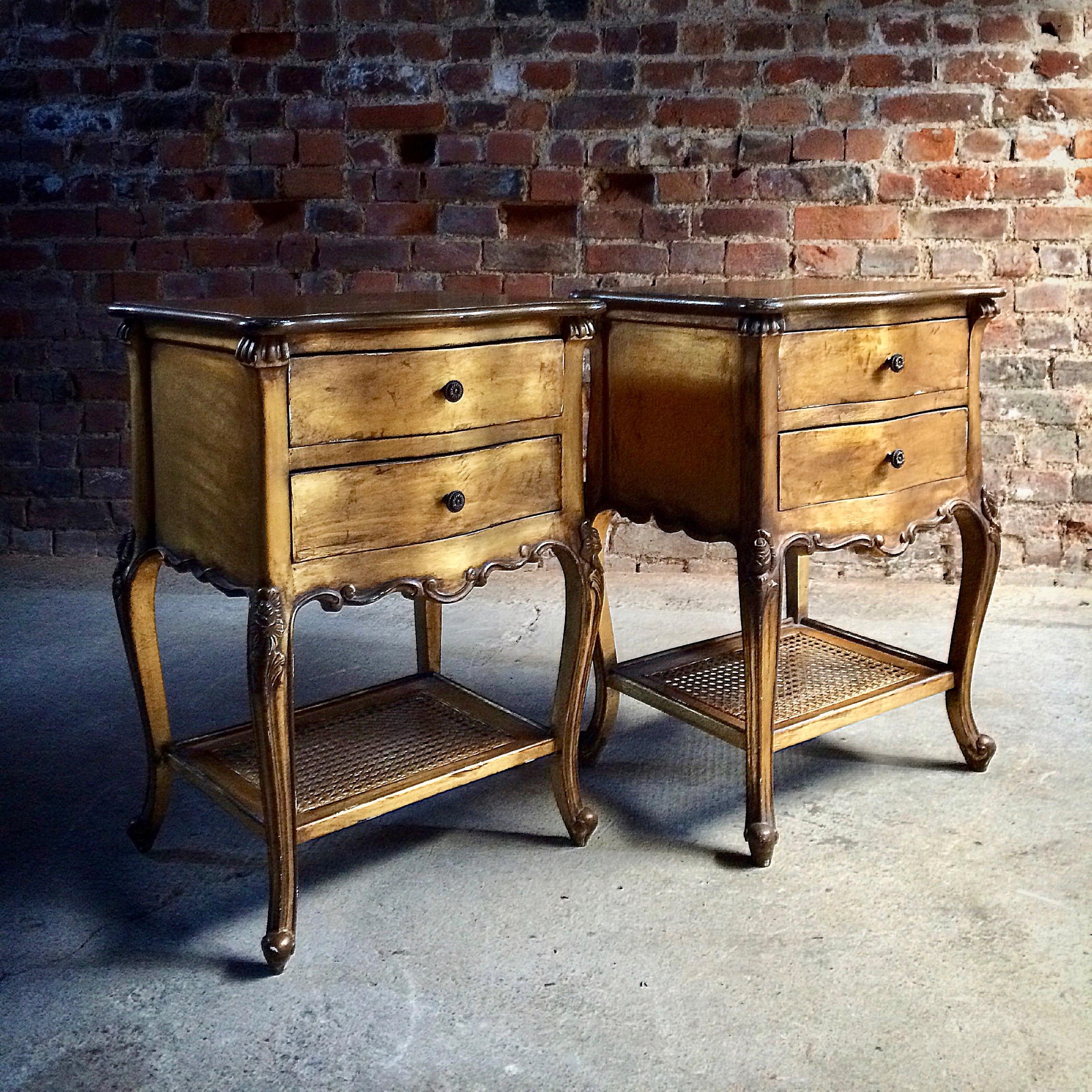 A magnificent pair of French period style bedside chests nightstands, 20th century, each being of classic serpentine outline and decorated in gilt, each featuring two drawers above a cane parcel shelf and raise on cabriole legs, the cabinets have a
