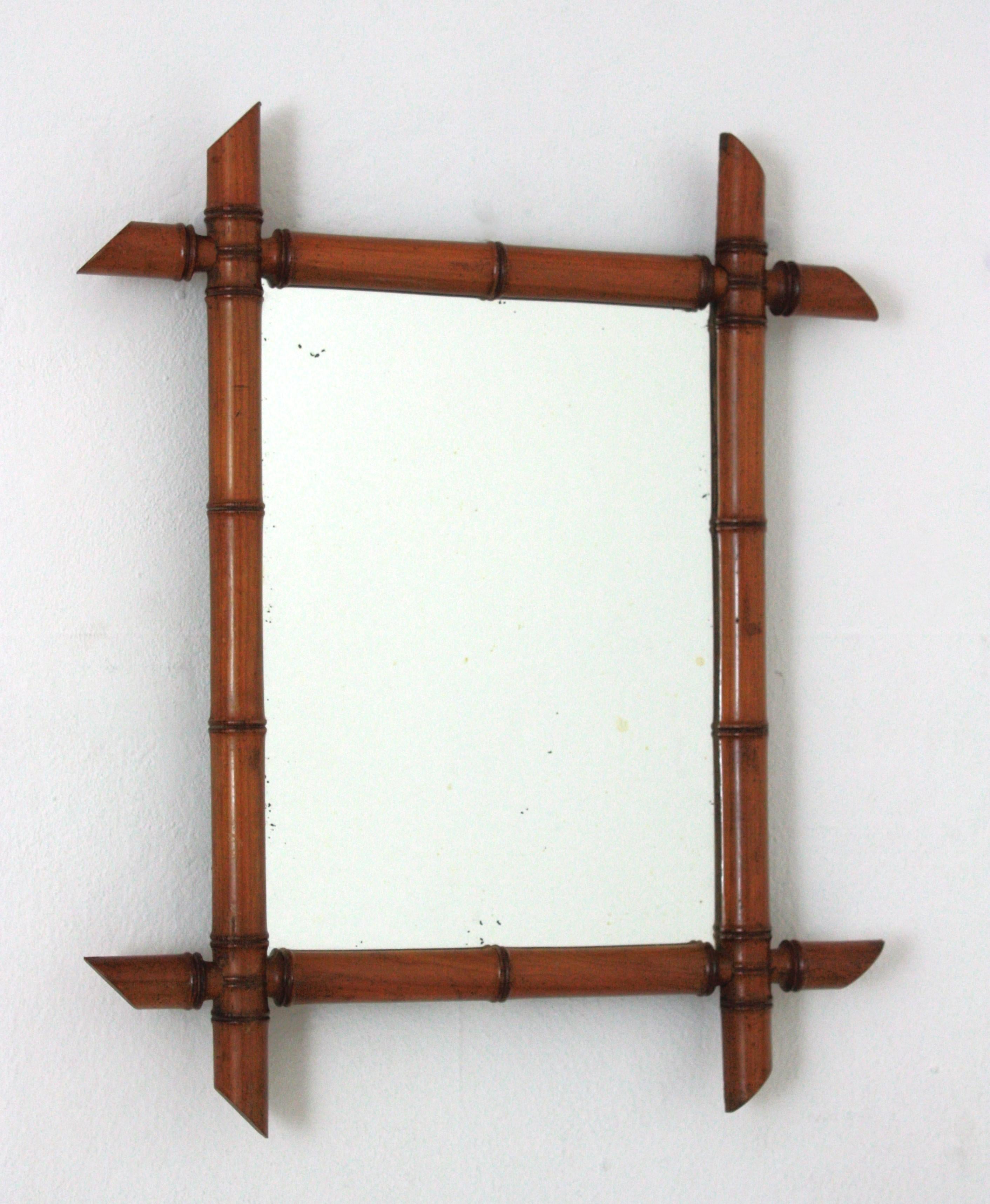 Französisch Mid-Century Modern Neoklassische gedreht Holz Spiegel Faux Bambus gerahmt,  im Stil von Jean-Michel Frank. Frankreich, 1930er-1940er Jahre.
Dieser Spiegel hat einen rechteckigen Rahmen aus braunem Bambusholzimitat mit sich