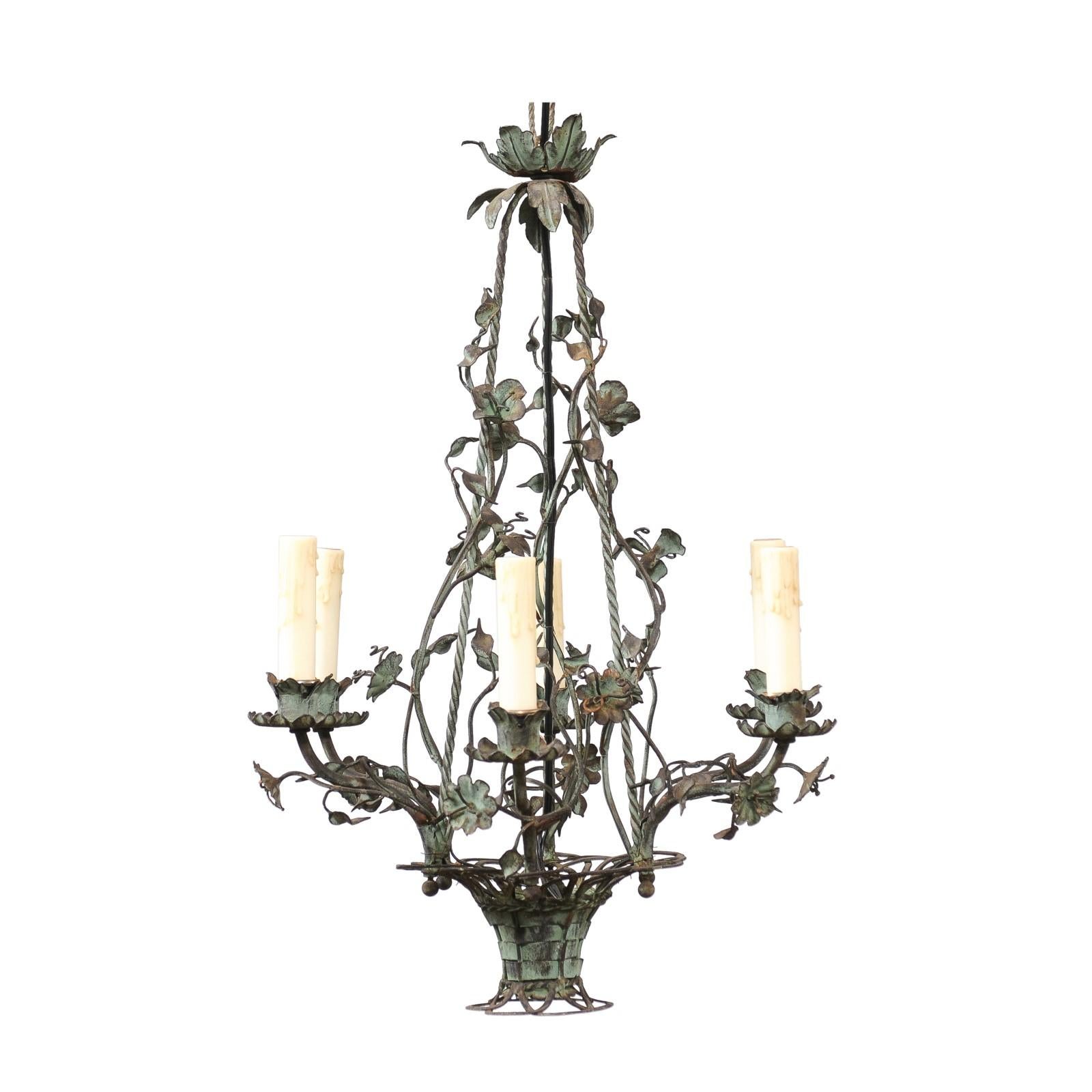 A French Belle Époque painted iron chandelier from circa 1900 with six lights, floral décor and verdigris patina. This French Belle Époque chandelier, dating back to around 1900, is a true testament to the opulence and intricate craftsmanship of its