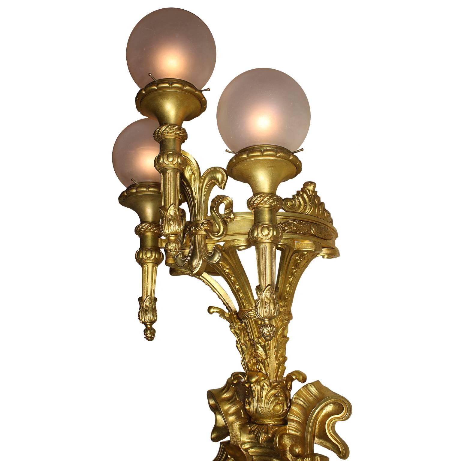A very fine and palatial French Belle Époque, 19th-20th century gilt-nronze three-light wall light with frosted glass globes. The allegorical ribbon and laurel gilt-bronze shield centred with a monogram with the initials 