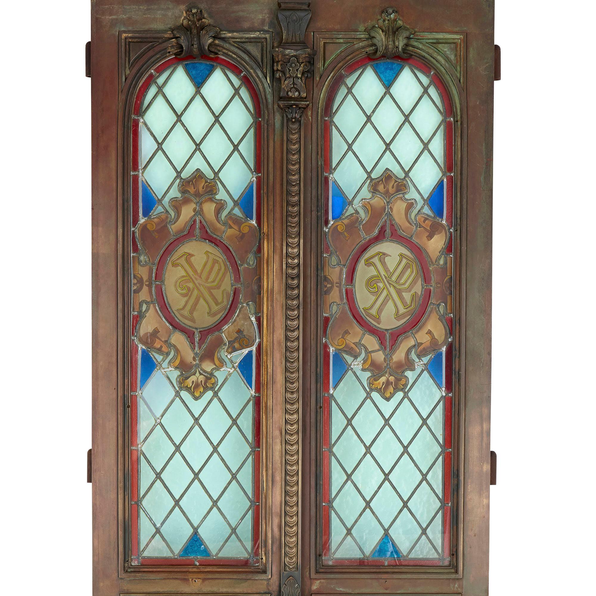 French Belle Époque bronze and stained glass doors
French, 1896
Each door: Height 210cm, width 41cm (82cm when together), depth 10cm

This magnificent pair of doors is crafted from bronze and stained glass. Each door contains arched-top