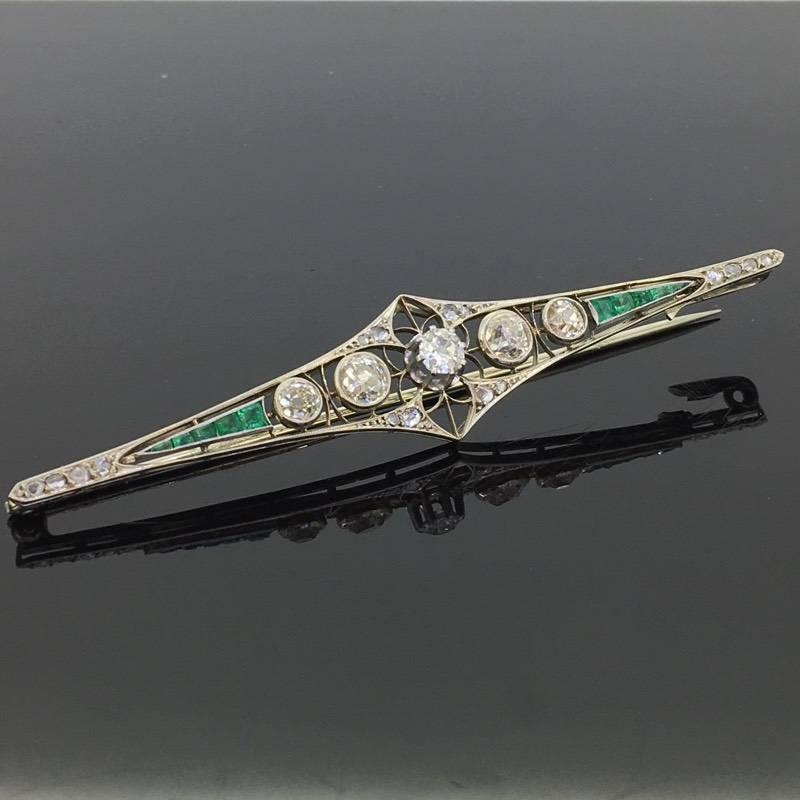 This beautiful brooch is made in 18kt white gold, it features 5 Old European cut diamonds with a total carat weight of 1.50ct approximately and 16 small rose cut diamonds. On both sides of the diamonds there are 10 calibrated emeralds which adding a