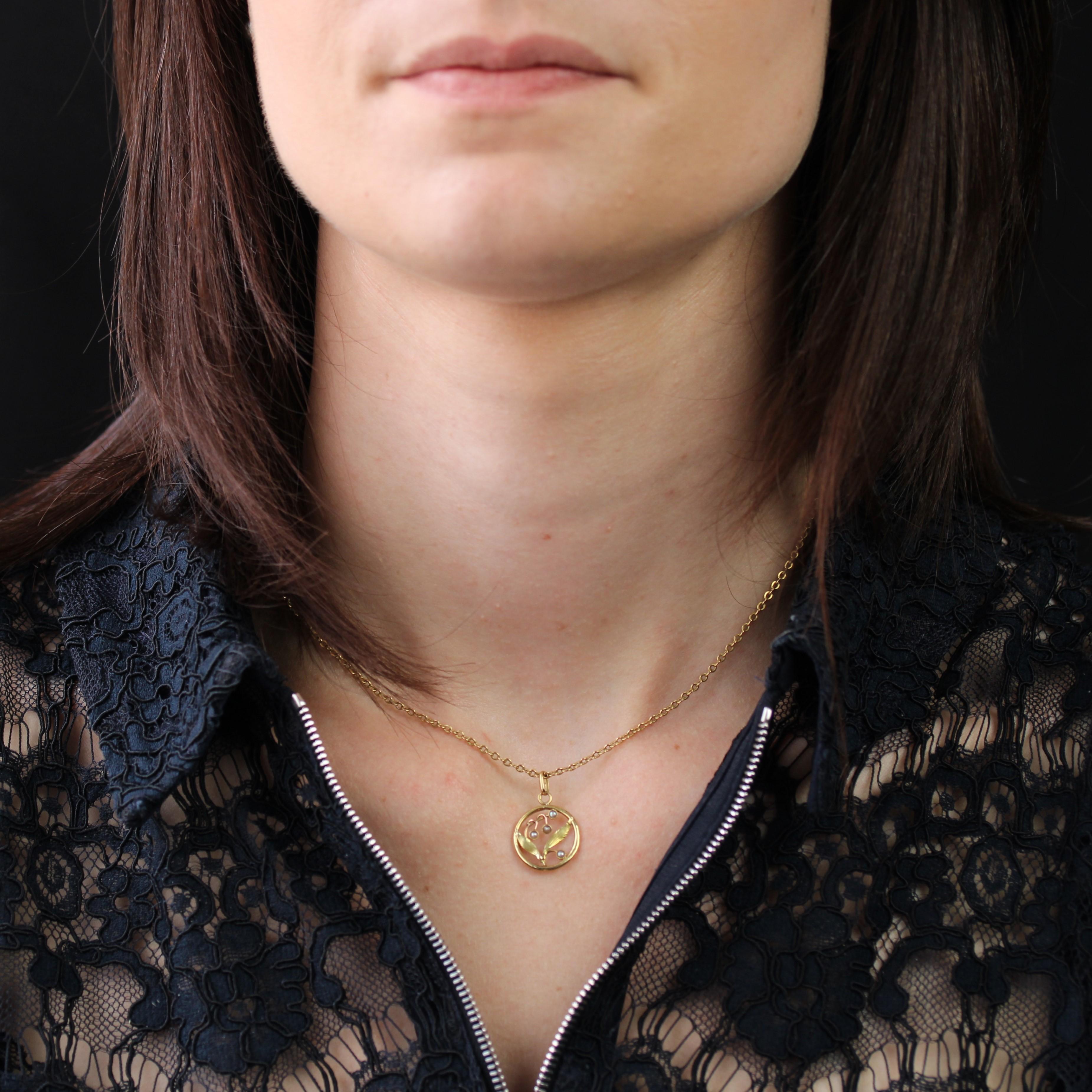 Pendant in 18 karats yellow and rose gold, eagle head hallmark.
A lovely round antique pendant, openworked and decorated in the center with a mistletoe leaf and 4 fine half-pearls.
Total height : 2.3 cm approximately, width at widest : 14.6 mm
