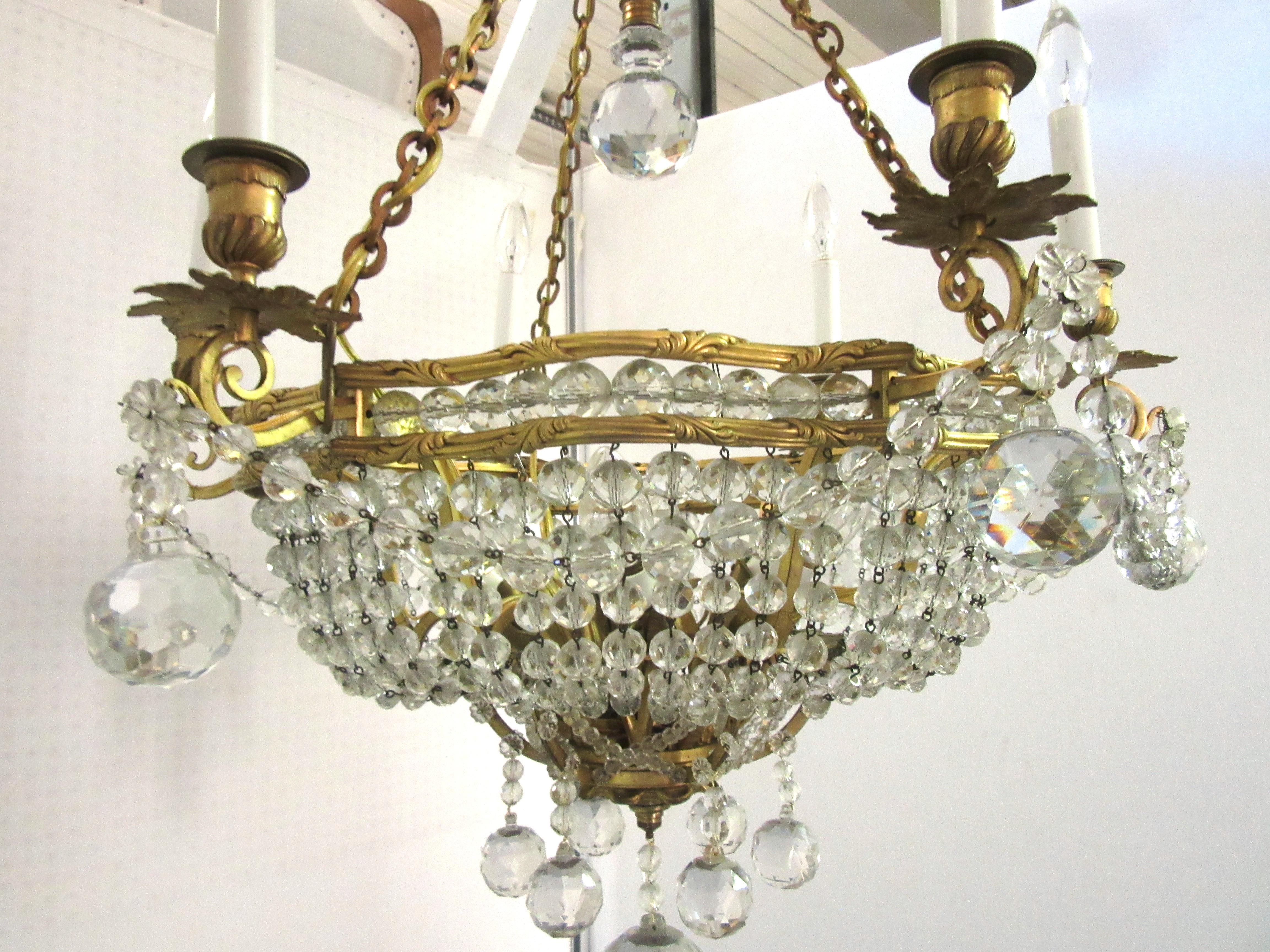 French Belle Époque gilt bronze chandelier with twelve lights. The piece has 18 cut crystal faceted spheres and numerous cut glass garlands. In great antique condition with age-appropriate wear and use. Recently restored to its original state.