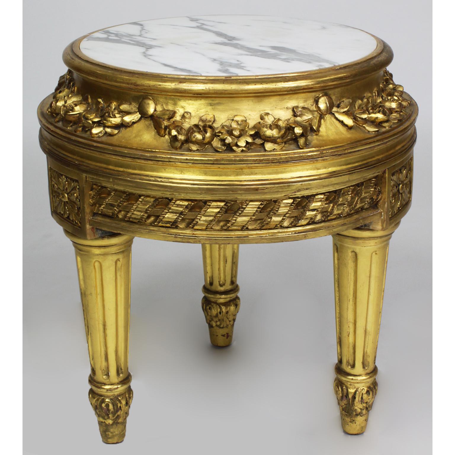 A French Belle Époque Louis XVI style giltwood carver pedestal stand with marble top. The circular pedestal with carvings of flowers and fitted with a veined white marble top, raised on three fluted legs. Paris, circa 1920.

Measures: Height 21