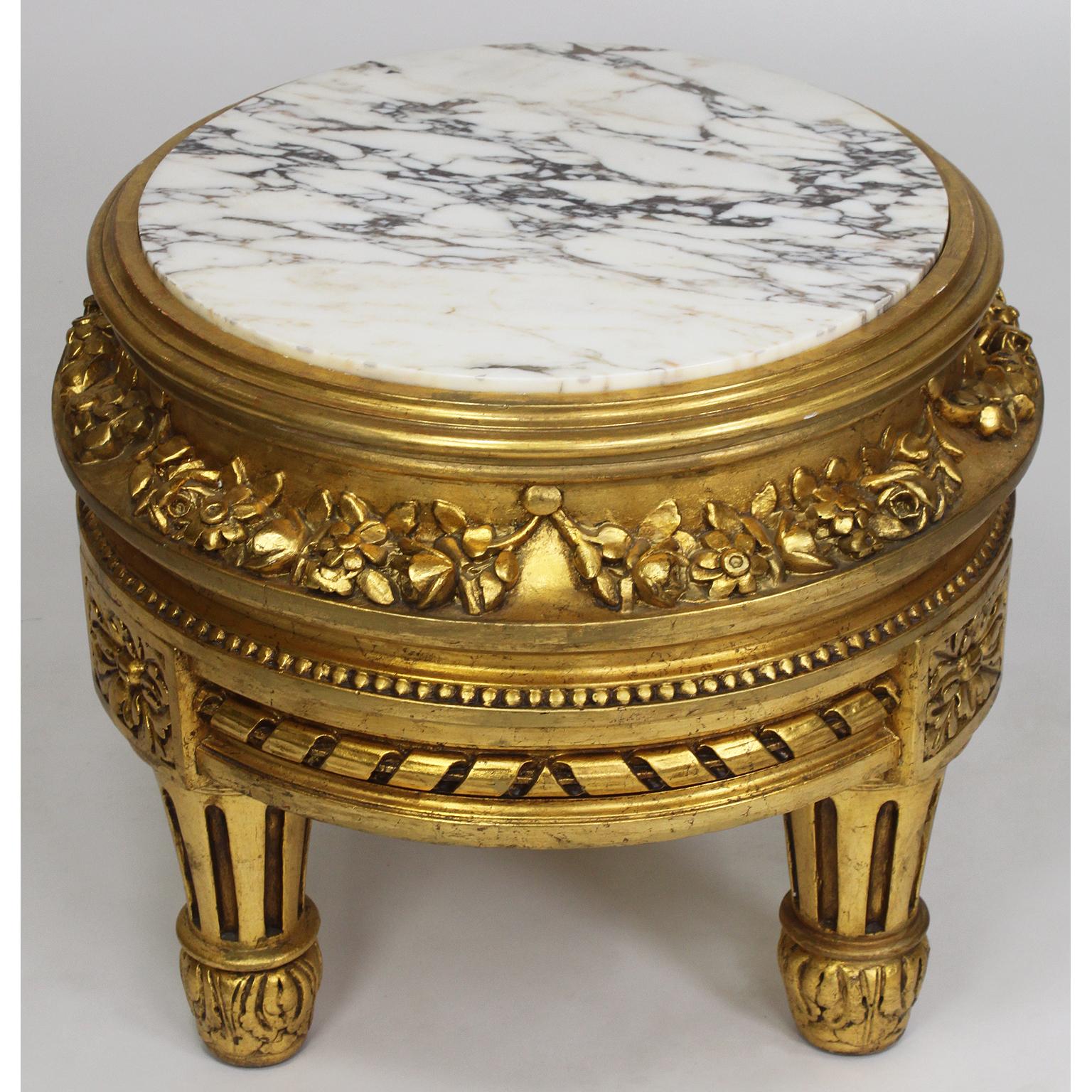 A French belle époque Louis XVI style giltwood carved pedestal stand with marble top. The circular pedestal with carvings of flowers and fitted with a veined white marble top, raised on three low fluted legs, Paris, circa 1920.

Measures: Height