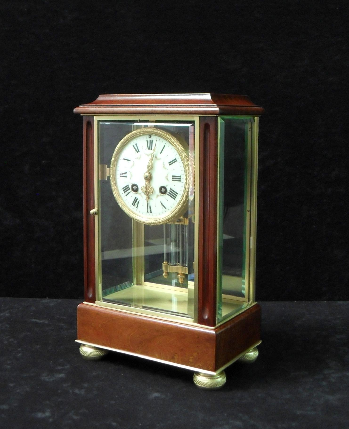 A good quality French mahogany four glass mantel clock with fluted front columns. The clock has a white enamel dial with painted detail and a French eight day movement which strikes the hours and half hours on a gong with compensating