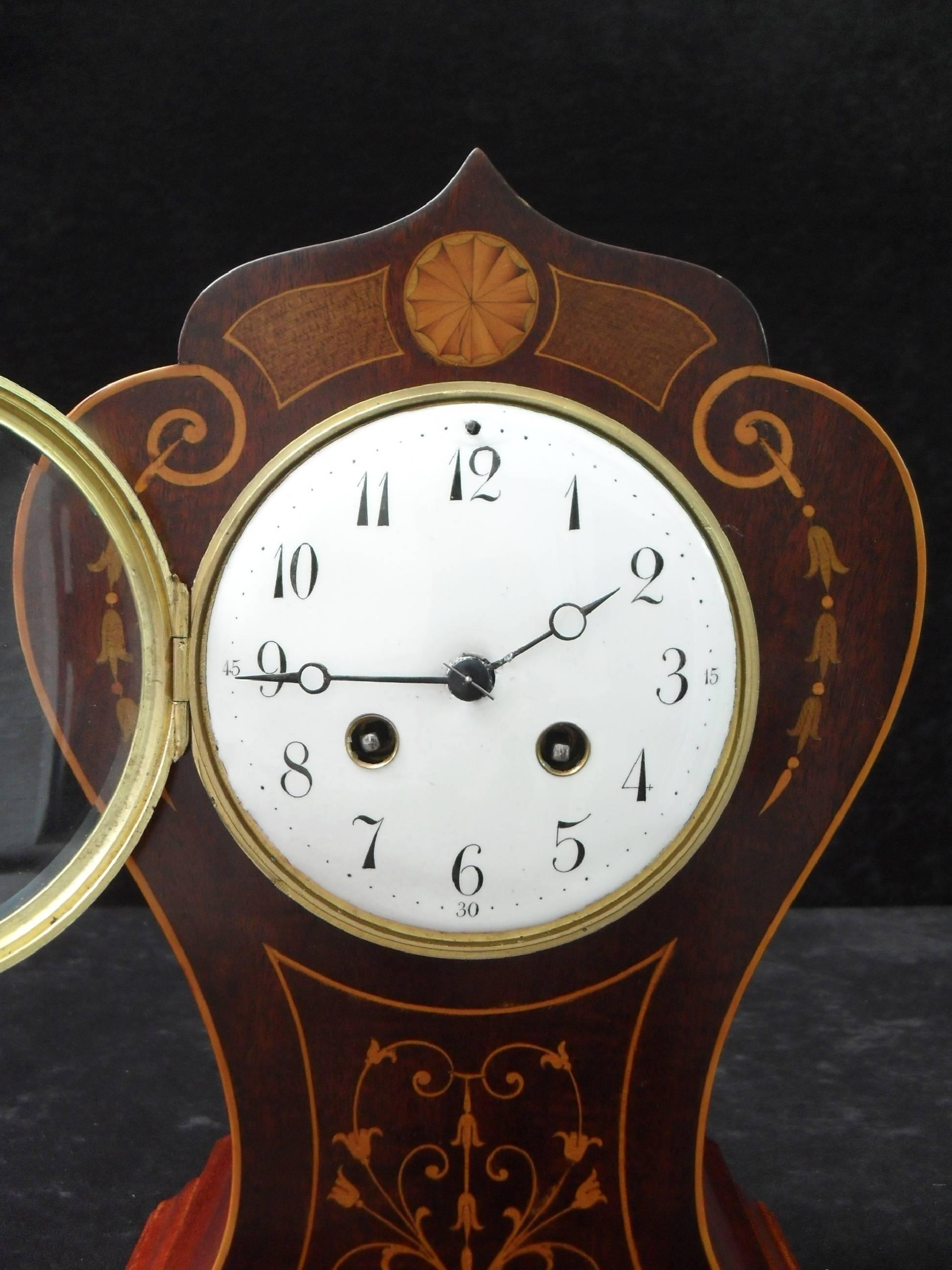 A very nice Belle Époque mahogany tulip shaped mantel clock with boxwood and coloured wood inlays and central fan to the top. The clock has a white enamel dial with a French eight day movement which strikes the hours and half hours on a gong.

The