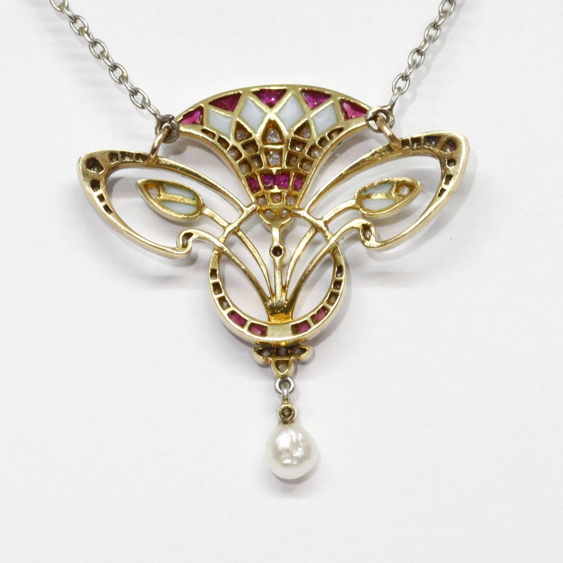 This beautiful french Belle Epoque pendant in the shape of a lotus flower testifies to the taste for Egyptian Antiquity during the first decades of the 20th century. It is set in 18k yellow gold and platinum with diamonds and calibré-cut rubies