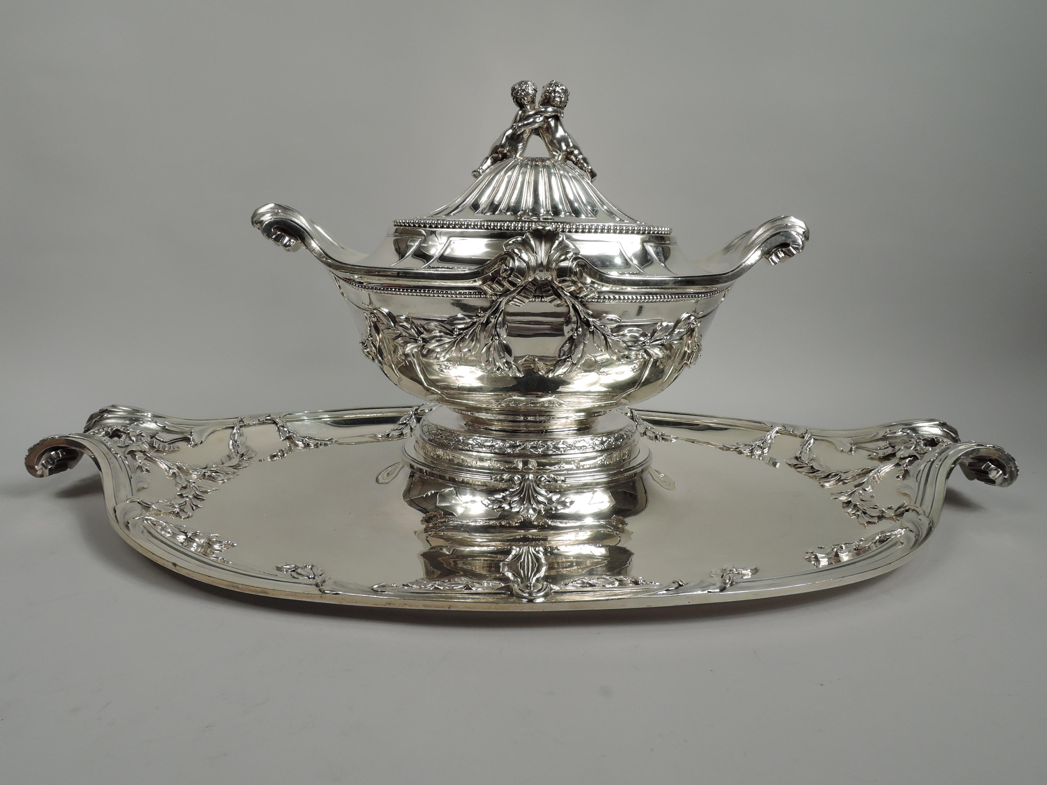 Belle Epoque Rococo soup tureen on stand. Made by Tetard Frères in Paris, ca 1910. Ovoid bowl with tapering sides and curved bottom with fluted and turned-down leaf handles. Sides have projecting volute scrolls inset with leaves. Leaves stippled and