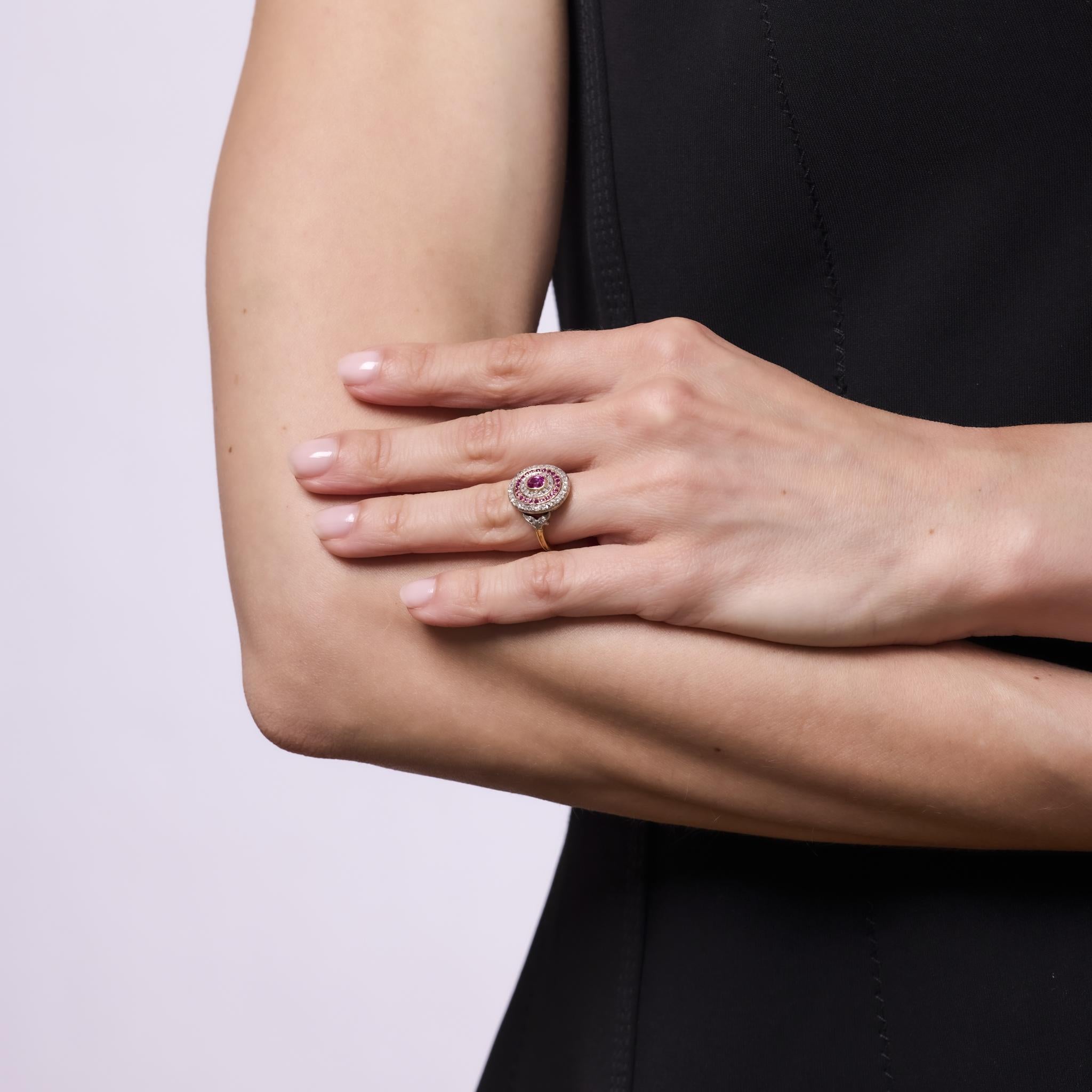 This enchanting French Belle Epoque ring features a cushion cut ruby framed by rose cut diamonds and additional ruby accents. Crafted in 18k yellow gold with a platinum top, its romantic design and delicate sparkle capture the refined elegance of