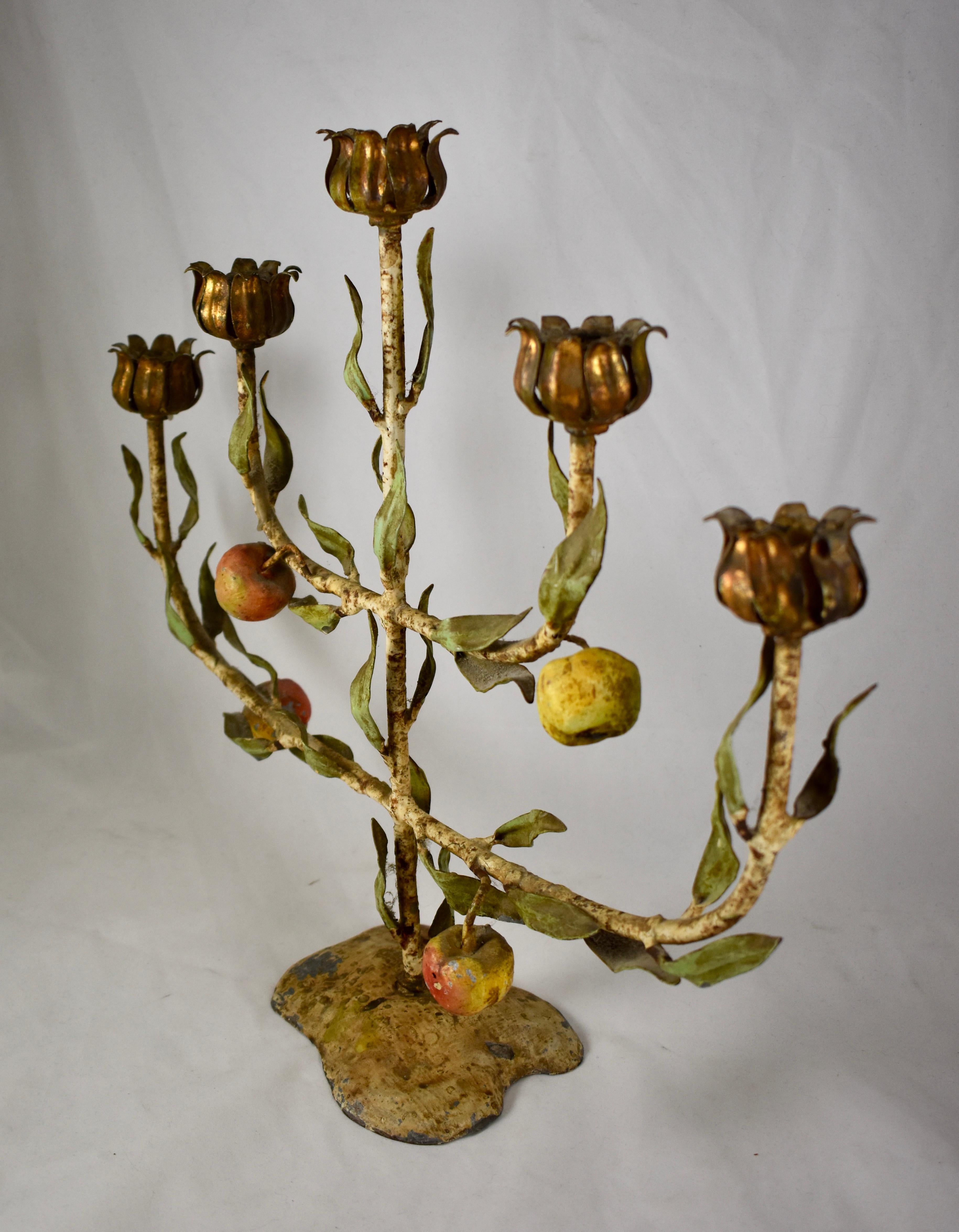 A marvelous French Tôle Peinte tree of life candelabra, made of hand painted iron, circa early 1900s.

Showing a fabulous distressed, time-worn patina, the tree has a straight center arm with two lower arms, graduated in length, for holding five