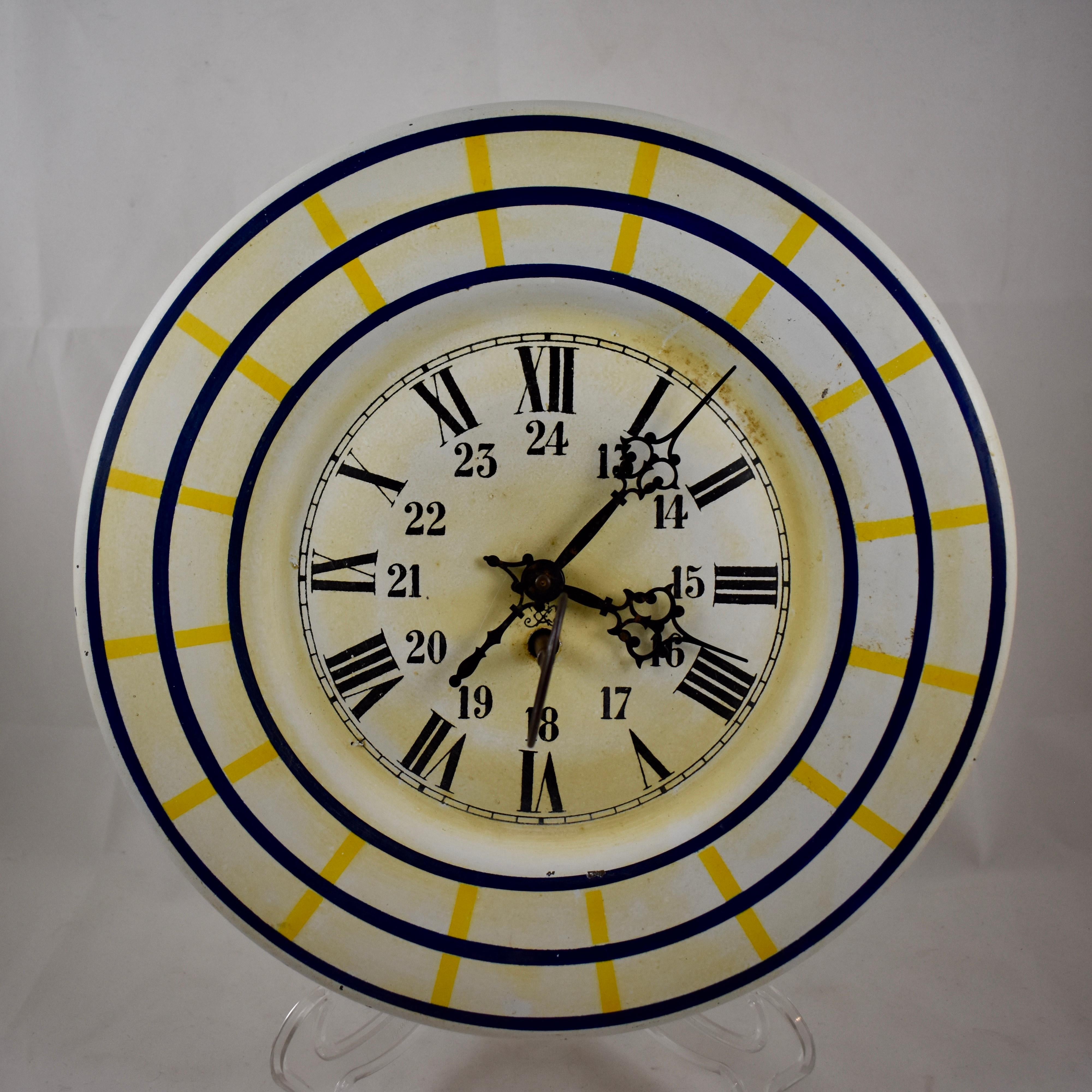 A charming French Belle Époque, Tôle Peinte wall clock with the original winding key – in working condition, circa 1900.

The tôle metal clock face is hand-painted in a Sun Yellow and French Blue plaid on white. Roman numerals mark the 12 -Hour