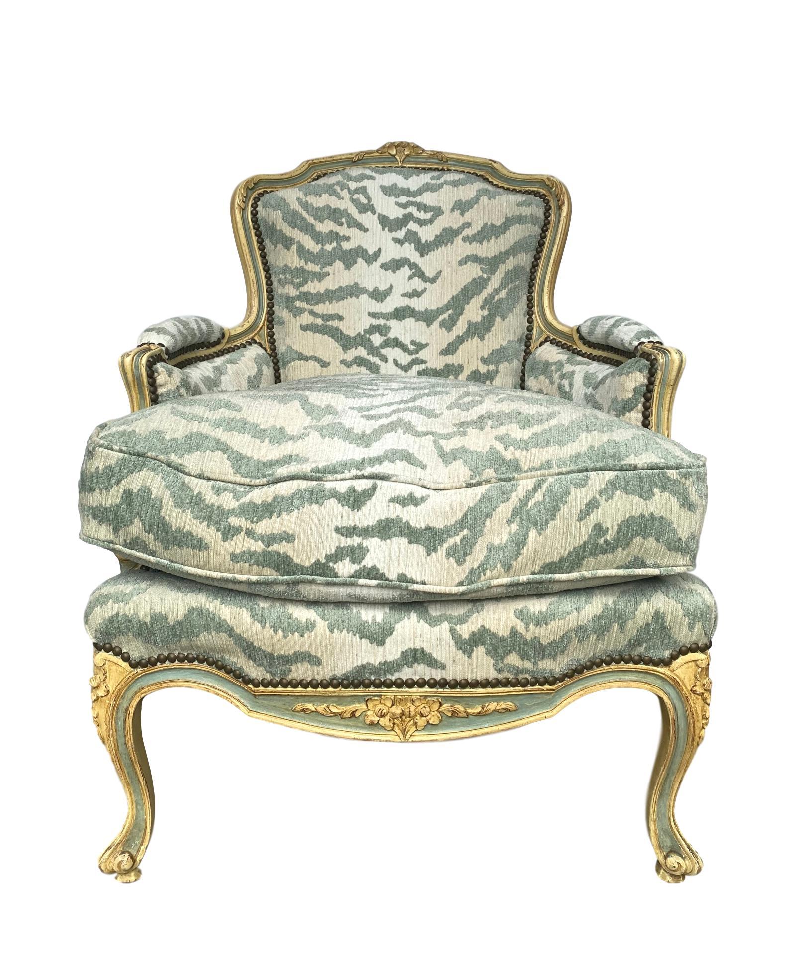French Bergère chair carved and painted in ivory and celadon blue, circa 1940. Newly upholstered in luxurious AJA-celadon tiger, trimmed with individual nailheads. Perfectly flow-matched, with a sumptuous cushion which is flow-matched on both