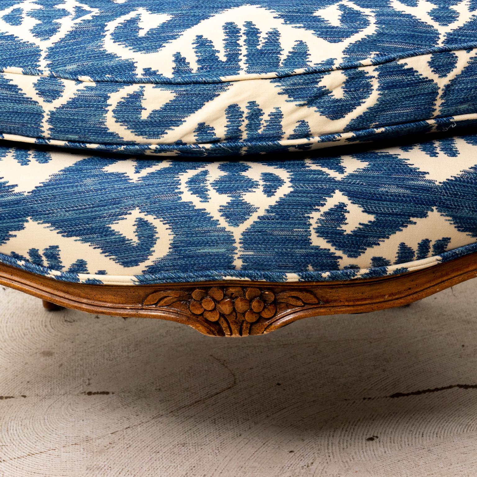 French Bergere armchairs upholstered in a blue and white fabric. The chair also features cabriole legs and upholstered arm rests. Please note of wear consistent with age.