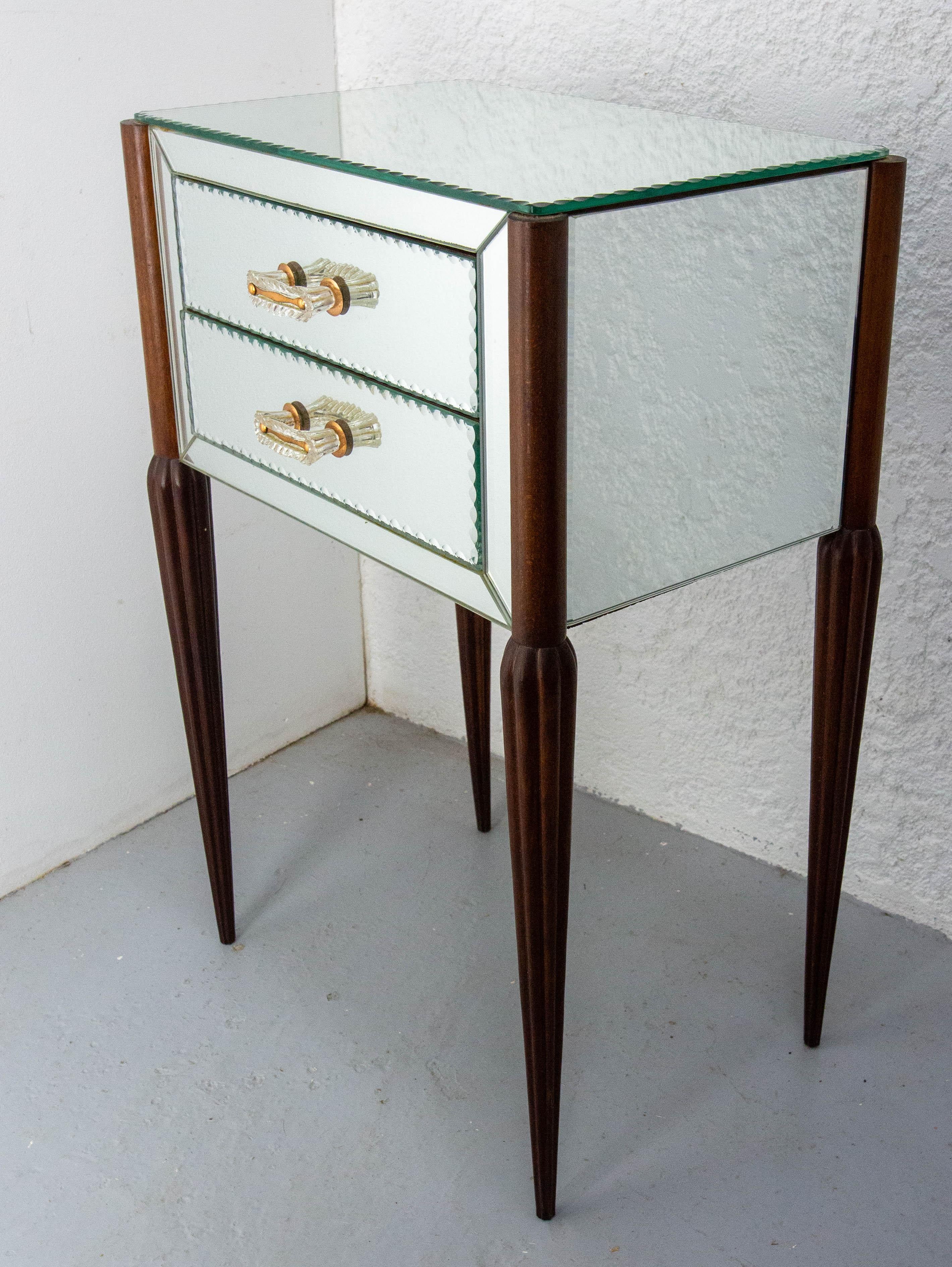 Meuble d'appoint à miroir français table de nuit chevet midcentury.
La pièce est en bois de hêtre mais a été entièrement recouverte de verre biseauté.
Chaque tiroir est orné d'une petite poignée en laiton et en verre.
Les pieds en hêtre sont