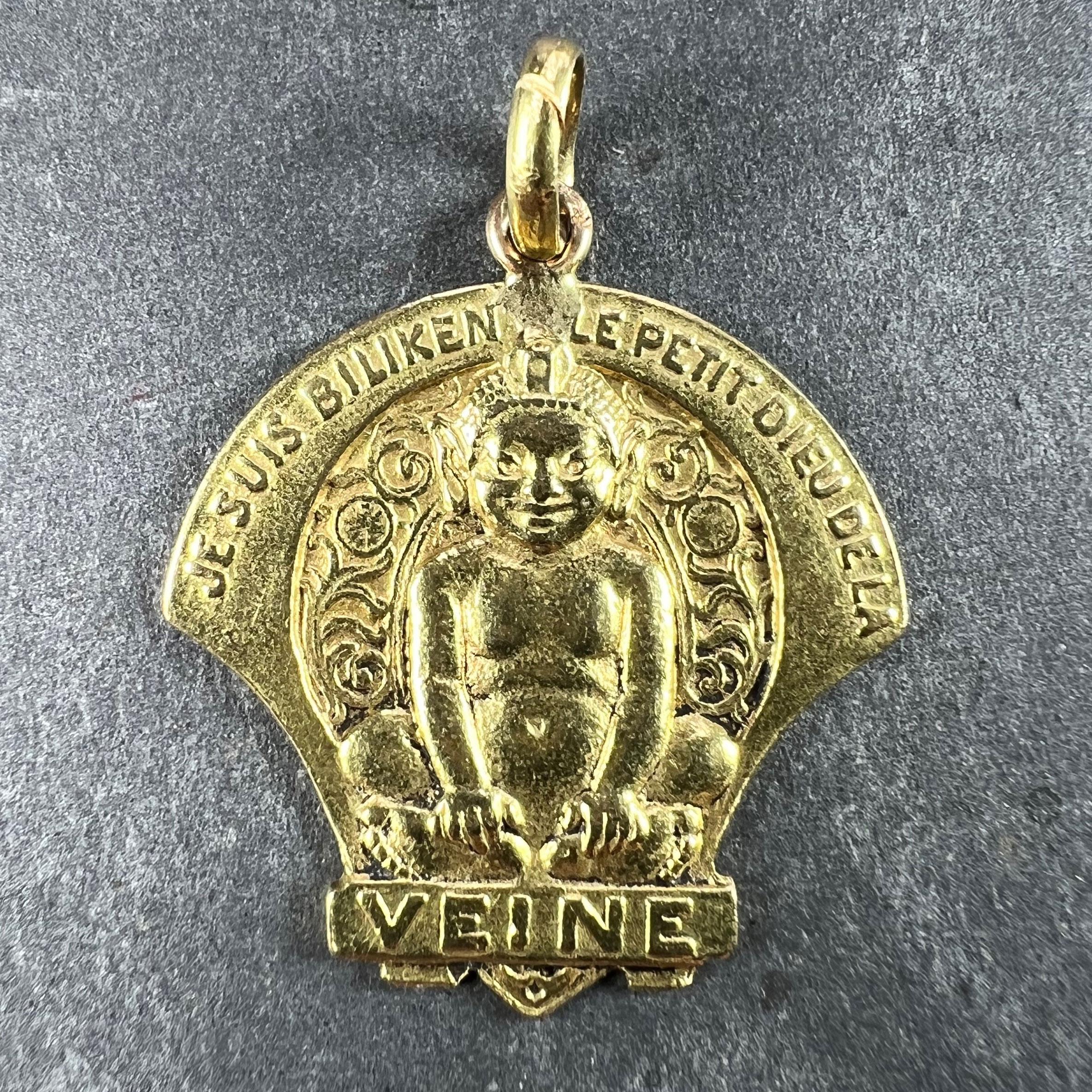 Un ciondolo portafortuna francese in oro giallo 18 carati (18K) disegnato come un elfo Biliken seduto come un Buddha con uno sfondo decorativo. La frase 