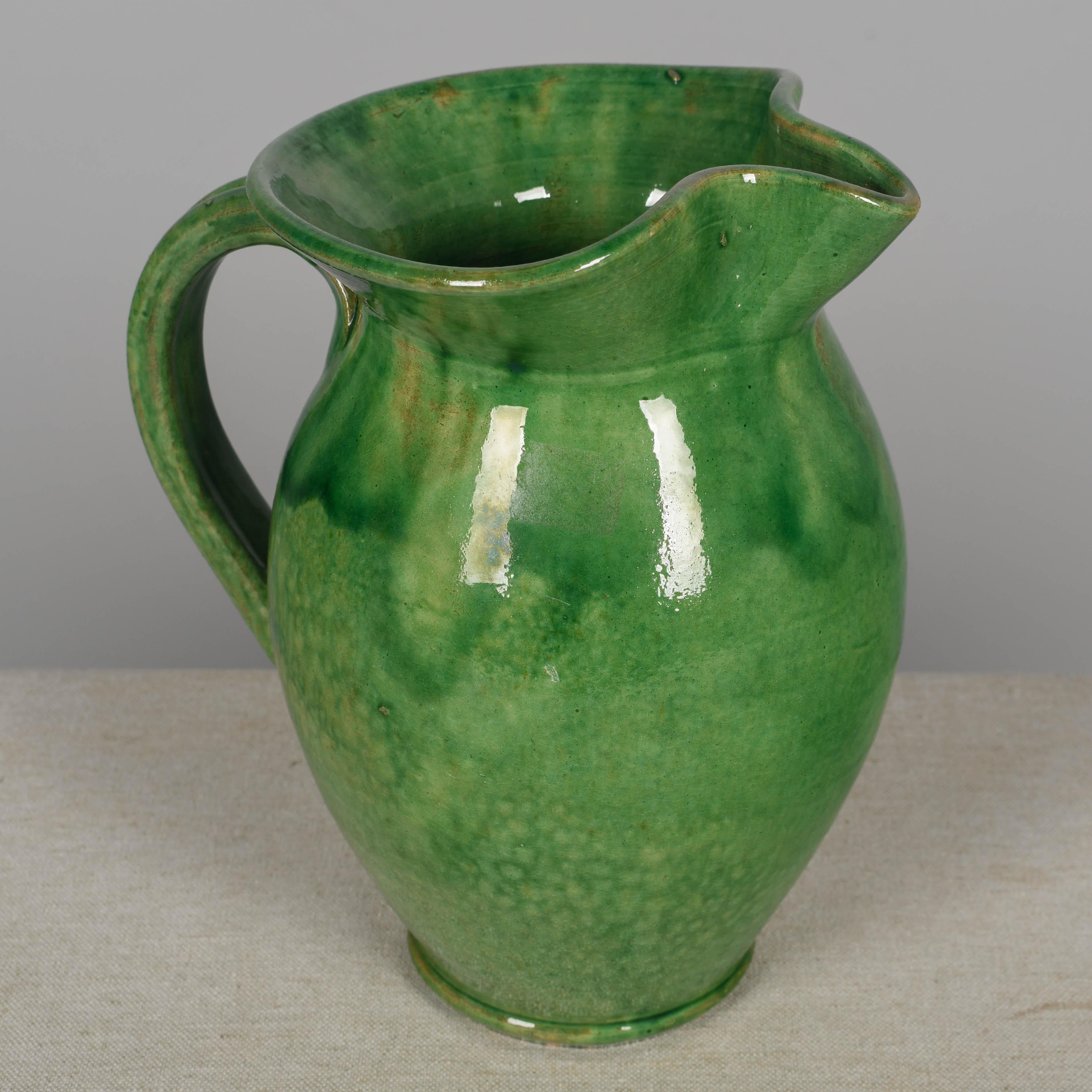 Juego de jarra y vinagrera de terracota esmaltada en verde de la cerámica francesa Biot. Vinagrera con tapón de corcho. Cada una en buen estado, con pequeñas pérdidas en el vidriado. Alrededor de 1950
Dimensiones: 
Jarra: 8,5