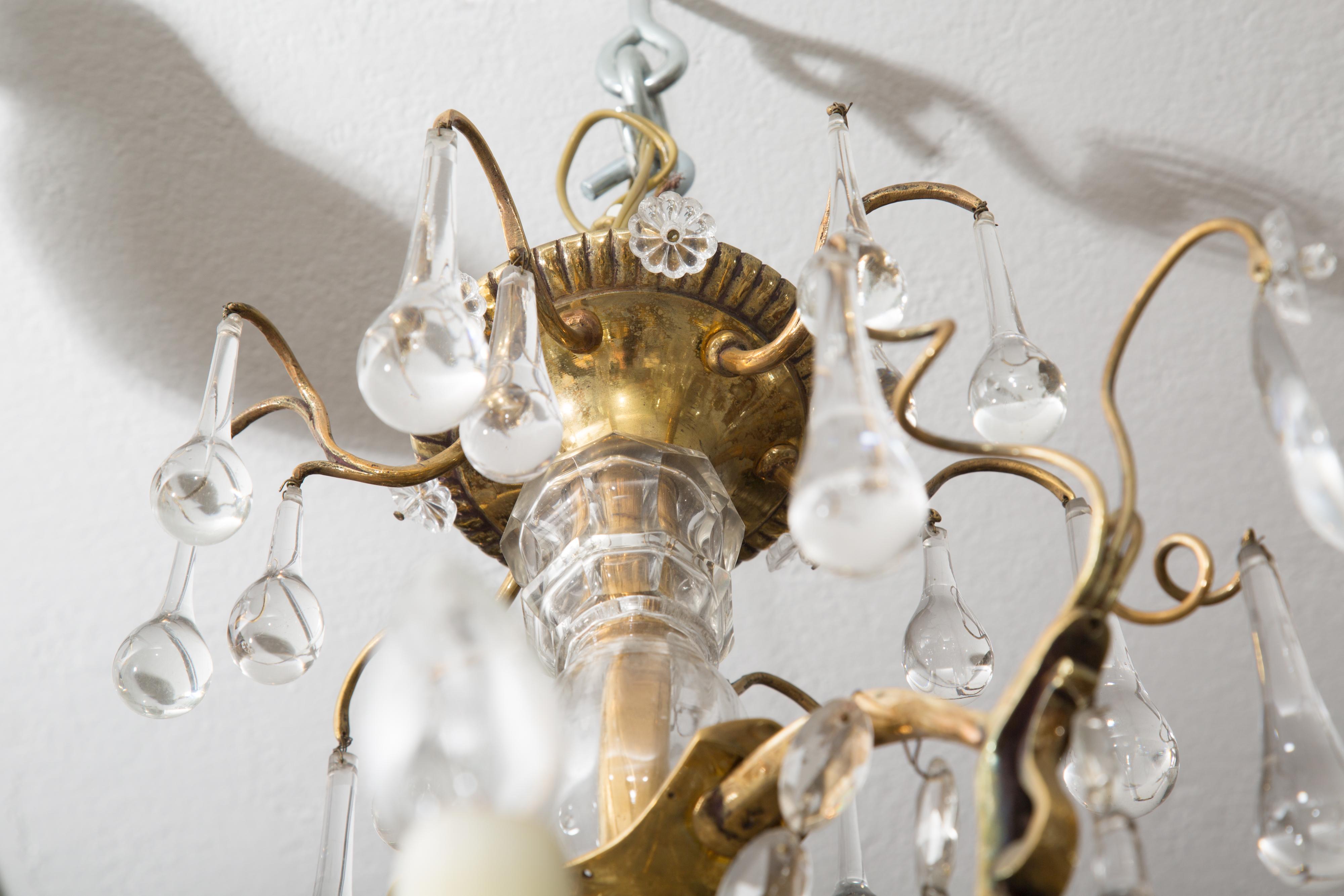 This is a unique French gilt bronze birdcage chandelier hung overall with tear-drop crystal pendants and elliptical crystal ropes. The fixture is centered by a crystal encased support, early 20th century.