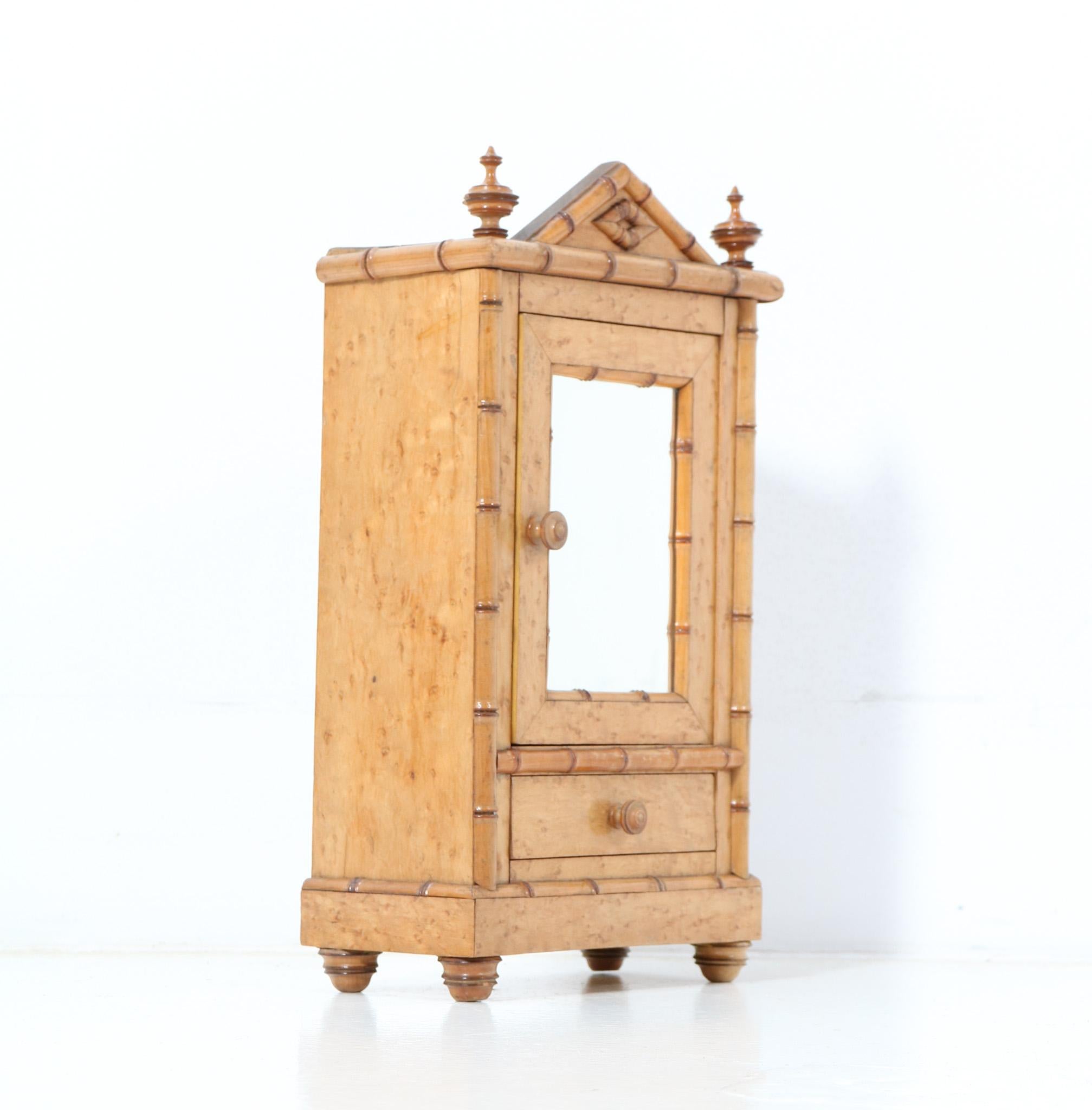 Magnificent and ultra rare French Provincial miniature armoire or wardrobe.
Striking French design from the 1900s.
Executed in birds-eye maple and faux bamboo, this stunning piece of craftsmanship is a true example of the exciting decorative