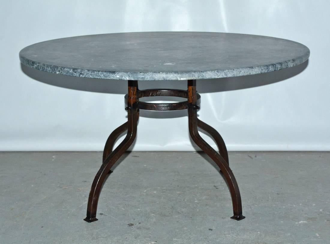 Indoor or outdoor French bistro style garden coffee table with round stone top paired with a bronze colored wrought iron base that is secured by gracefully arched legs and round stretcher. Top and base can be sold separately. Top: 1500/base: 1900.