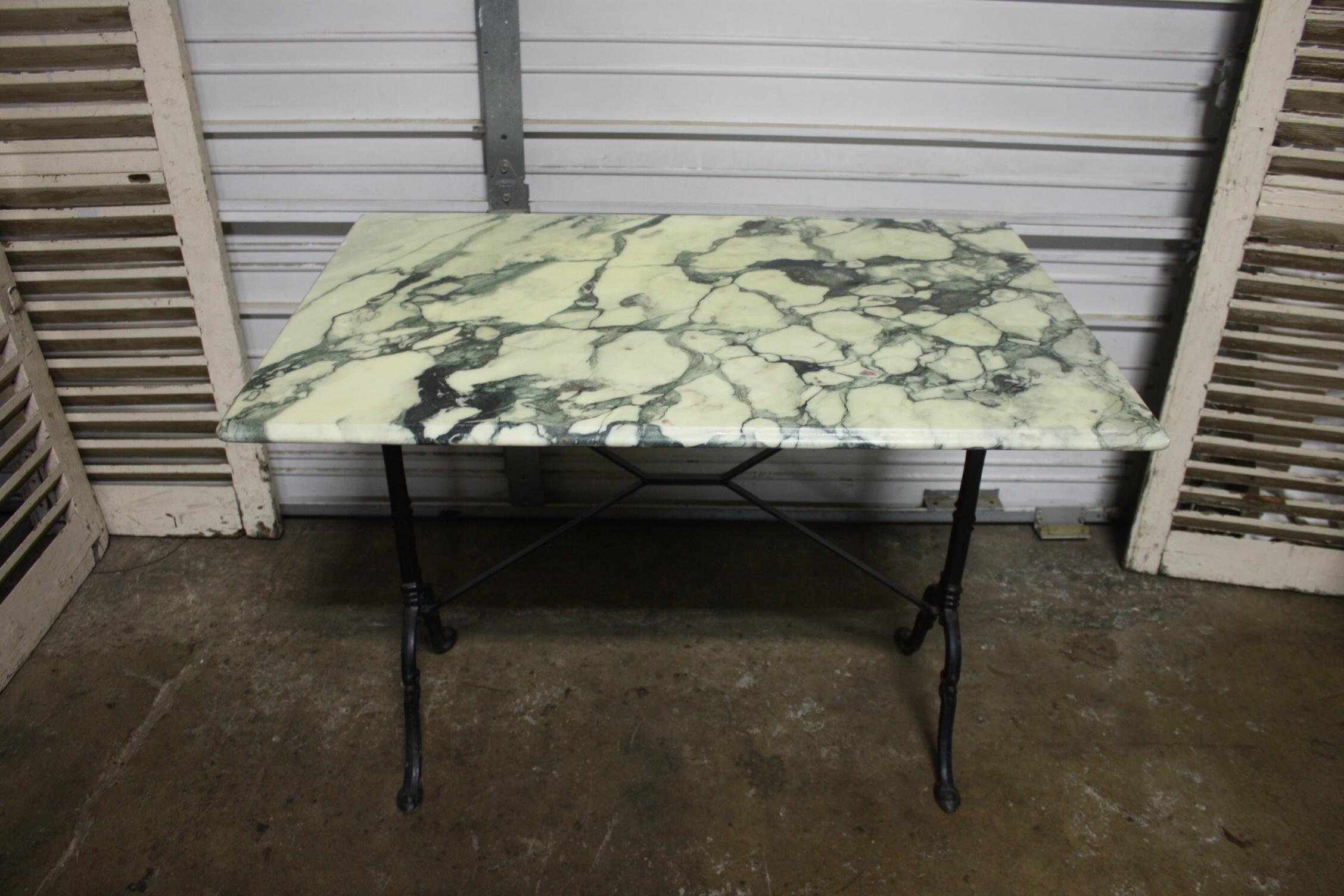 Cette table bistro a un étonnant plateau en marbre avec des veines de couleur verte. Il peut être placé à l'intérieur ou à l'extérieur.