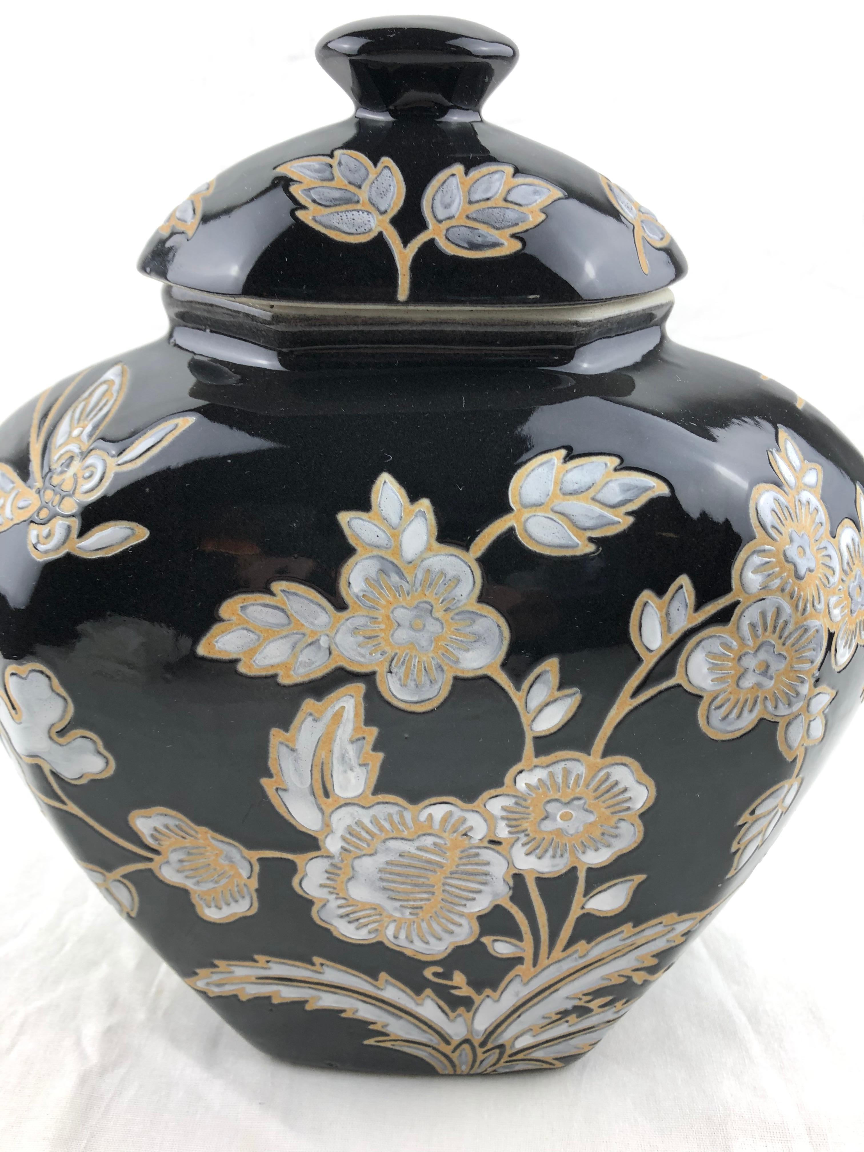 A lovely lidded French Majolica porcelain jar with molded floral and foliage decor. 
This very good quality piece is handcrafted with great details throughout. 

This Majolica jar boasts a lovely black body adorned with delicately molded flowers,