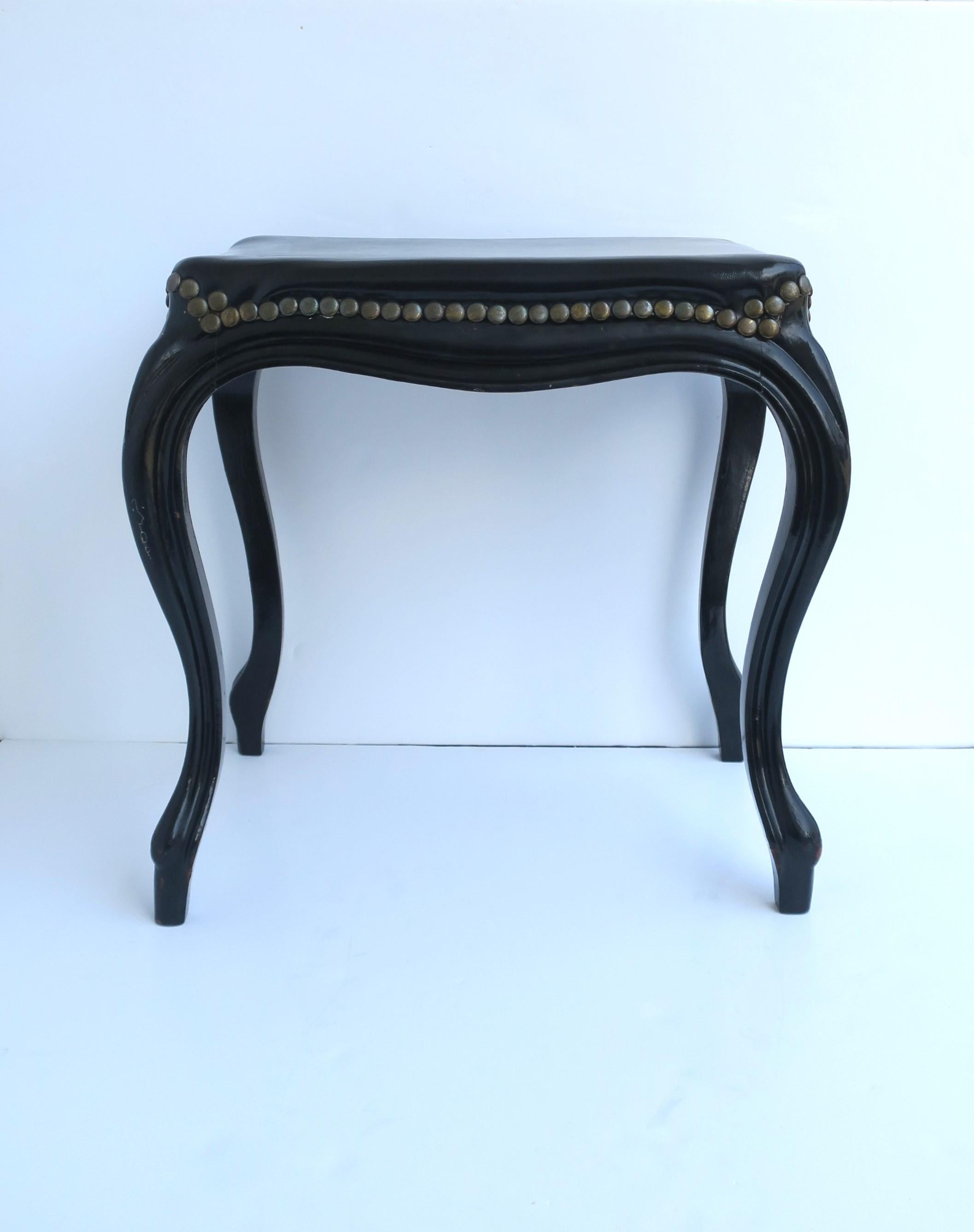 A chic French black wood bench or stool, Rococo Revival period, circa early-20th century, France. Bench or stool has beautiful Rococo Revival/Art Nouveau lines, a black lacquer high-gloss base, upholstered in a quality black pleather (faux-leather)