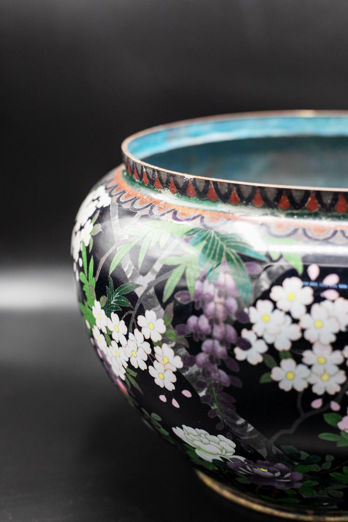 A beautiful decorated French cloisonné vase belonging to the 1900s, of fine French manufacture.
The vase has a smaller but round base bordered in gold. The vase then widens to take an ovoid shape and narrows again at the neck. The neck is traversed