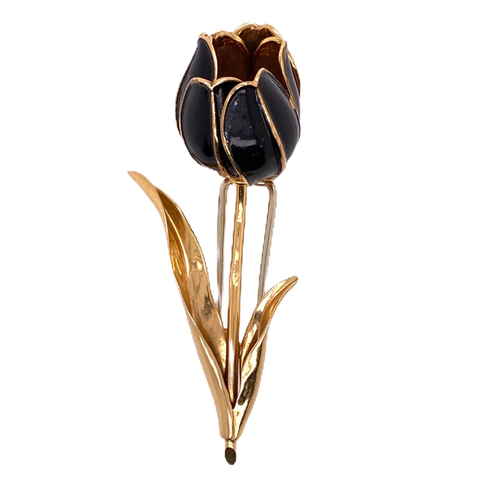 Beautifully handcrafted tulip pin fashioned in 18 karat yellow gold. The French brooch features black enamel petals that open and close, and ruby gemstones inside. The flower measures 2.25 inches in length, 1.0 inch in width, and is hallmarked and