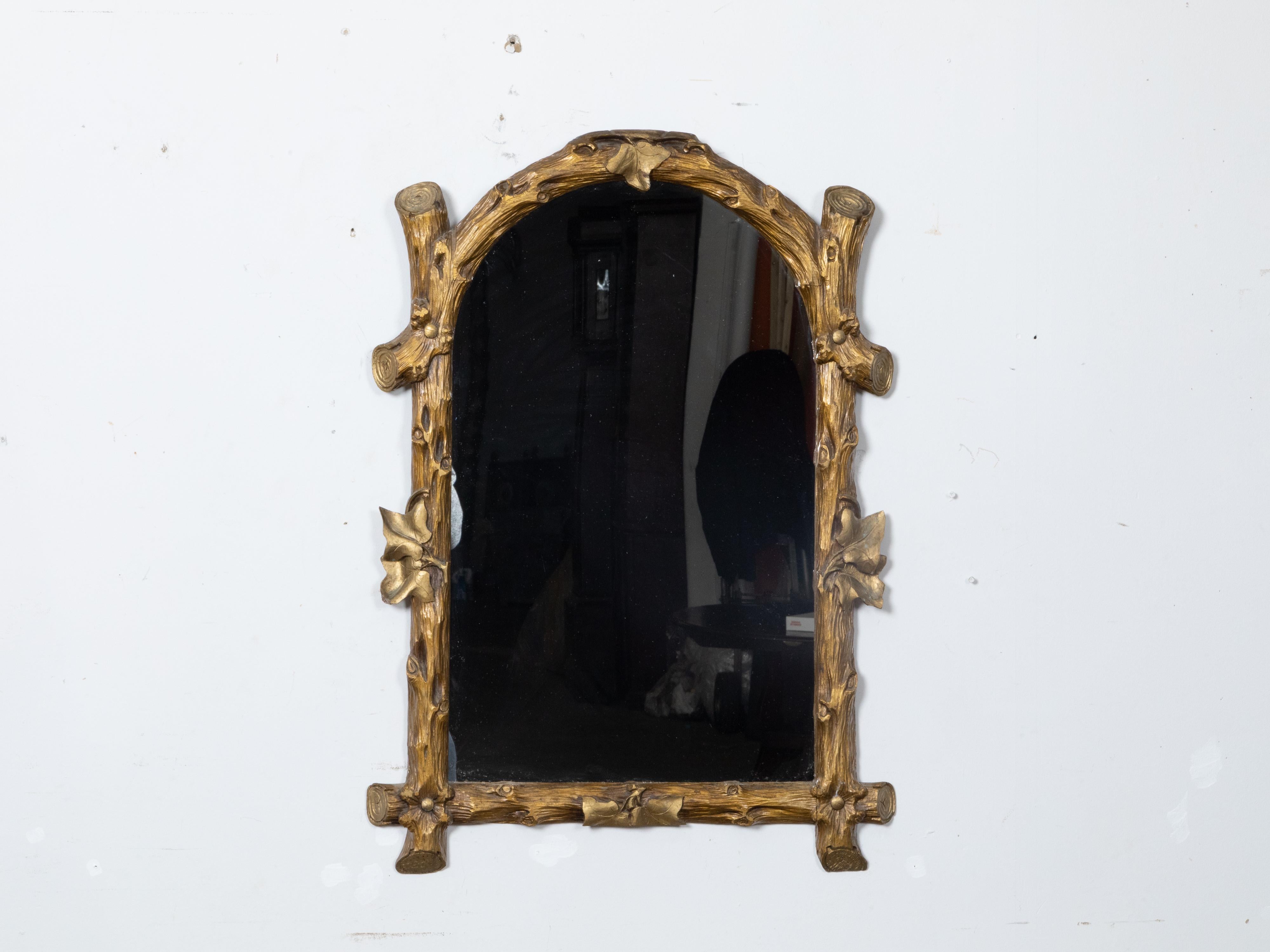 This French Black Forest period carved giltwood faux bois mirror, dating back to circa 1900, will draw the viewer's attention with its intricate design, ivy motifs and masterful craftsmanship. The mirror embodies the essence of the Black Forest